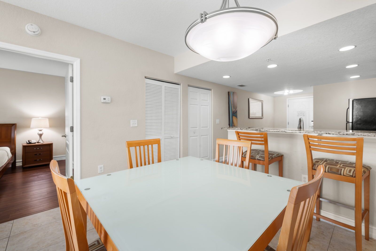 image Gather around the glass-top dining table for a meal or game night in this cozy space.