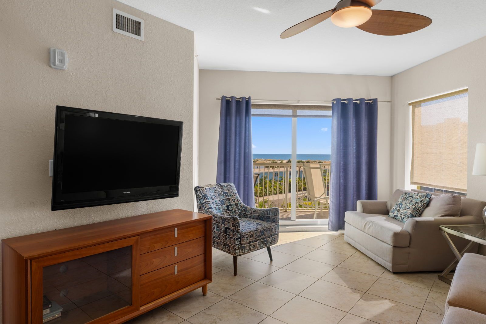 image Relax and unwind in the living room, complete with a flat-screen TV and lovely views of the balcony.