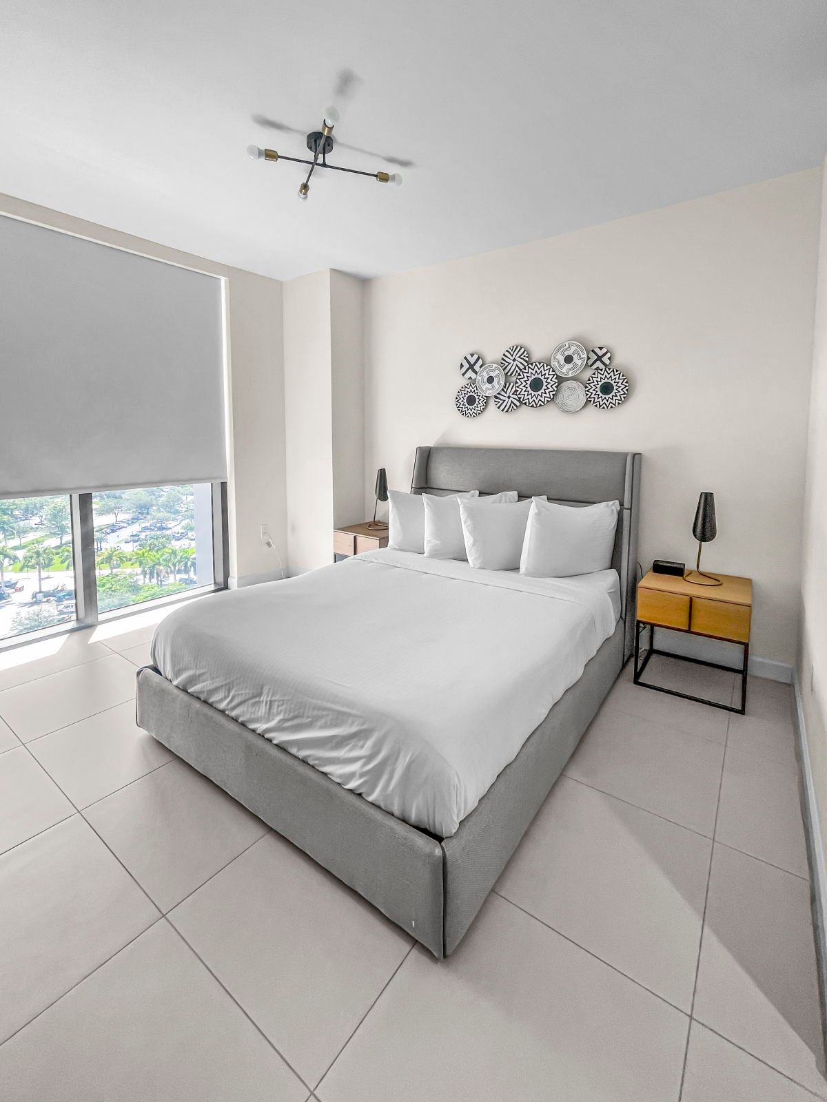 image Unwind in a spacious room featuring a plush queen bed, stylish decor, and floor-to-ceiling windows.