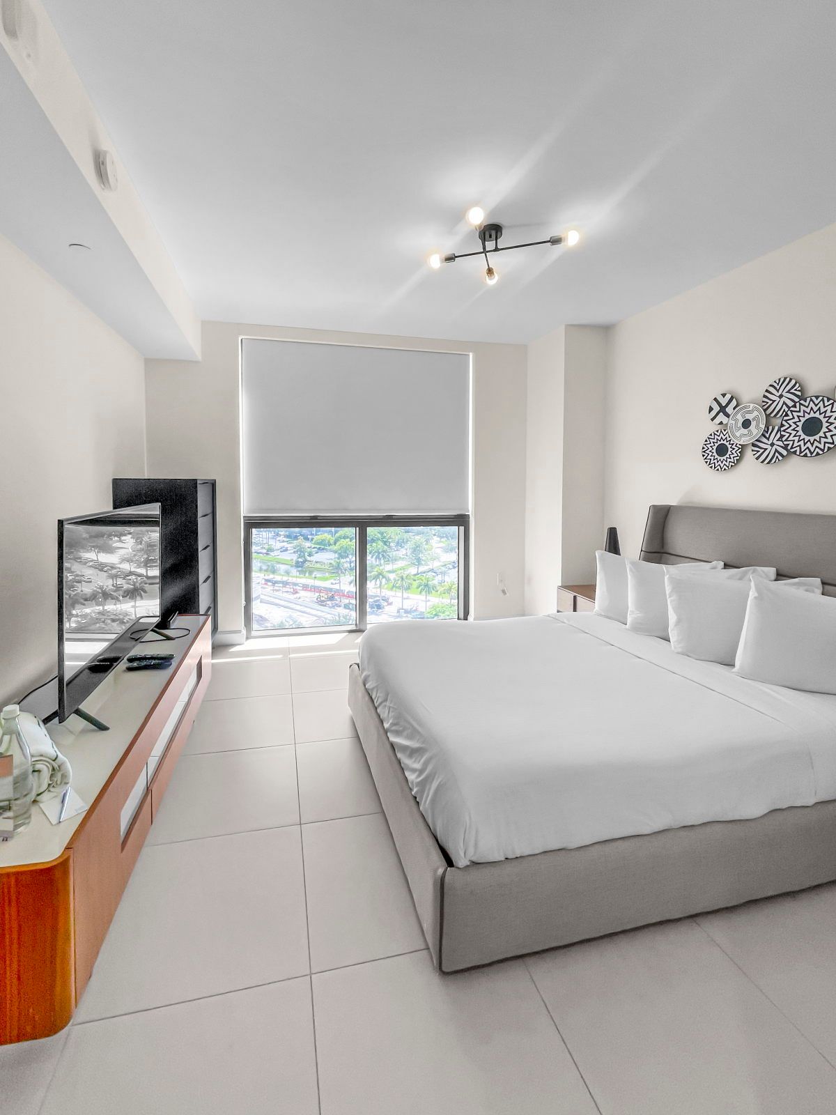 image Unwind in a stylish bedroom with a plush queen bed, Smart TV, and striking decor.