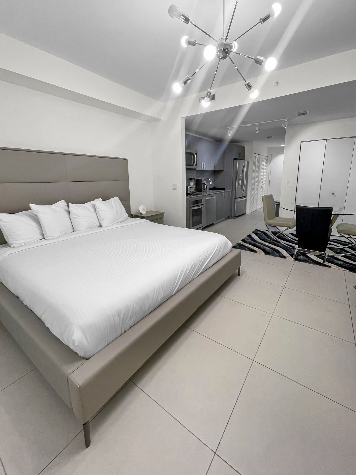 image Relax in the inviting king bed, surrounded by contemporary decor and warm lighting.