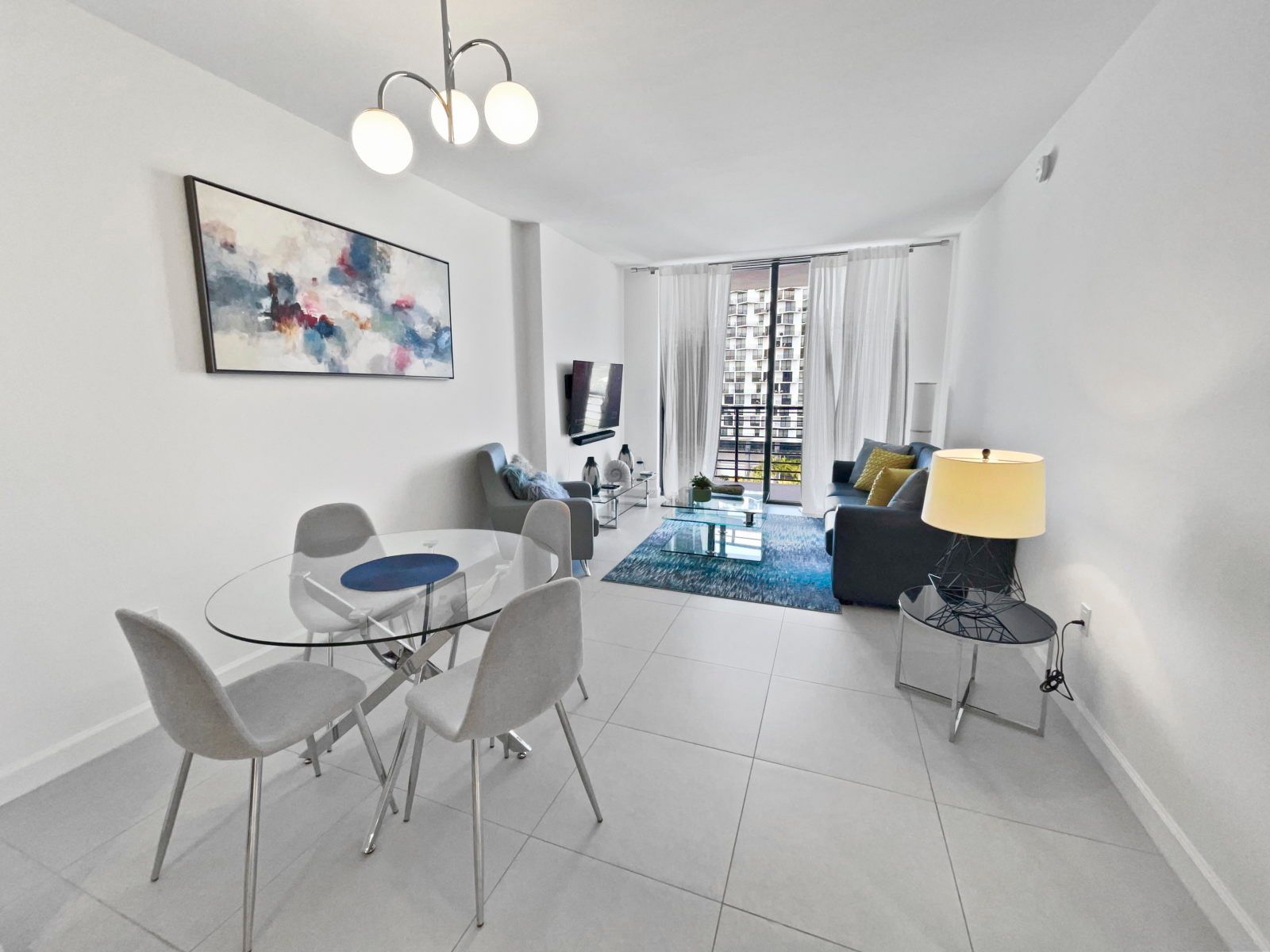 image Relax in the cozy living area, with plush seating and natural light pouring in through the balcony doors.