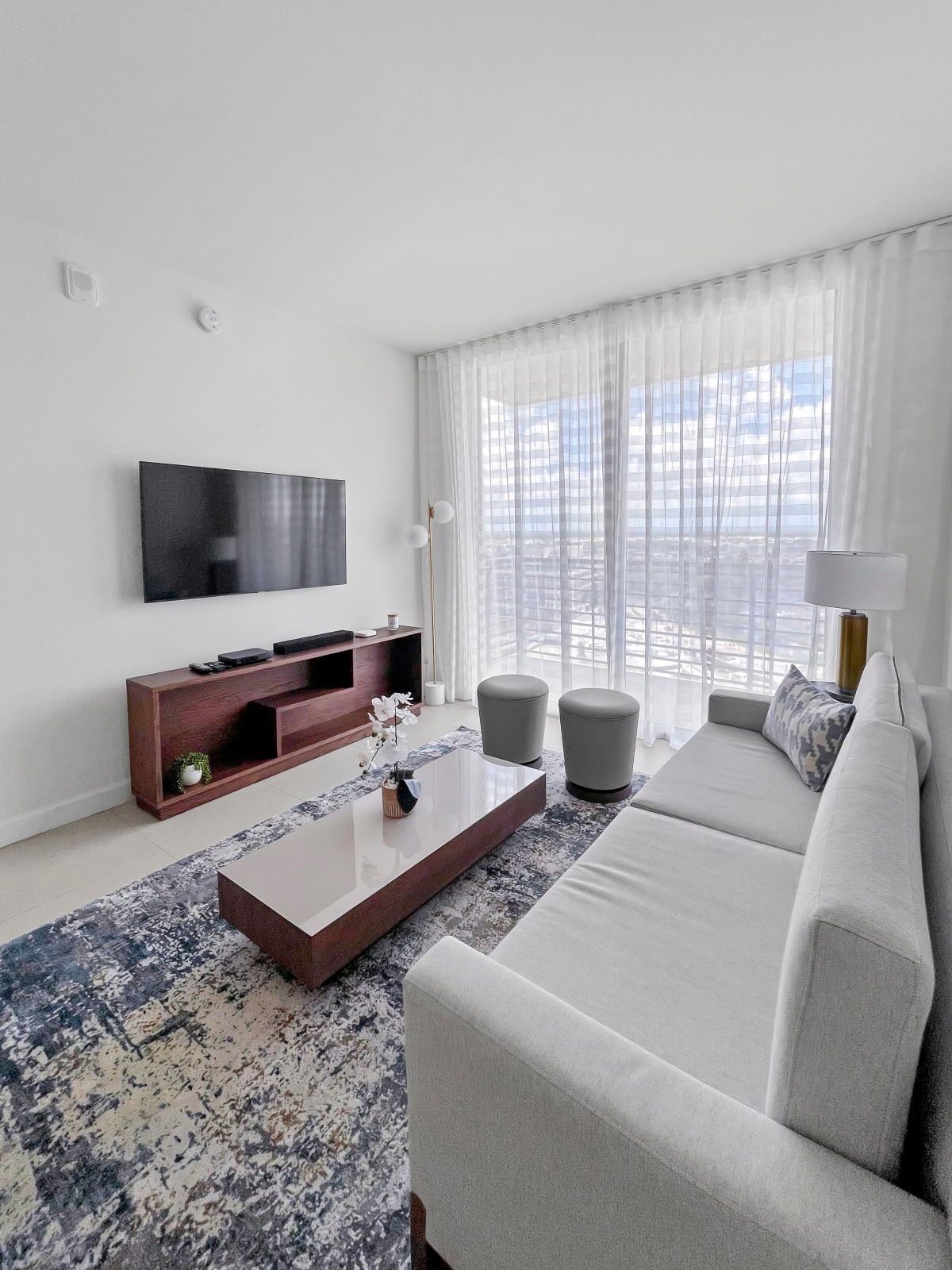 image Relax on the plush sofa surrounded by natural light streaming through floor-to-ceiling windows.