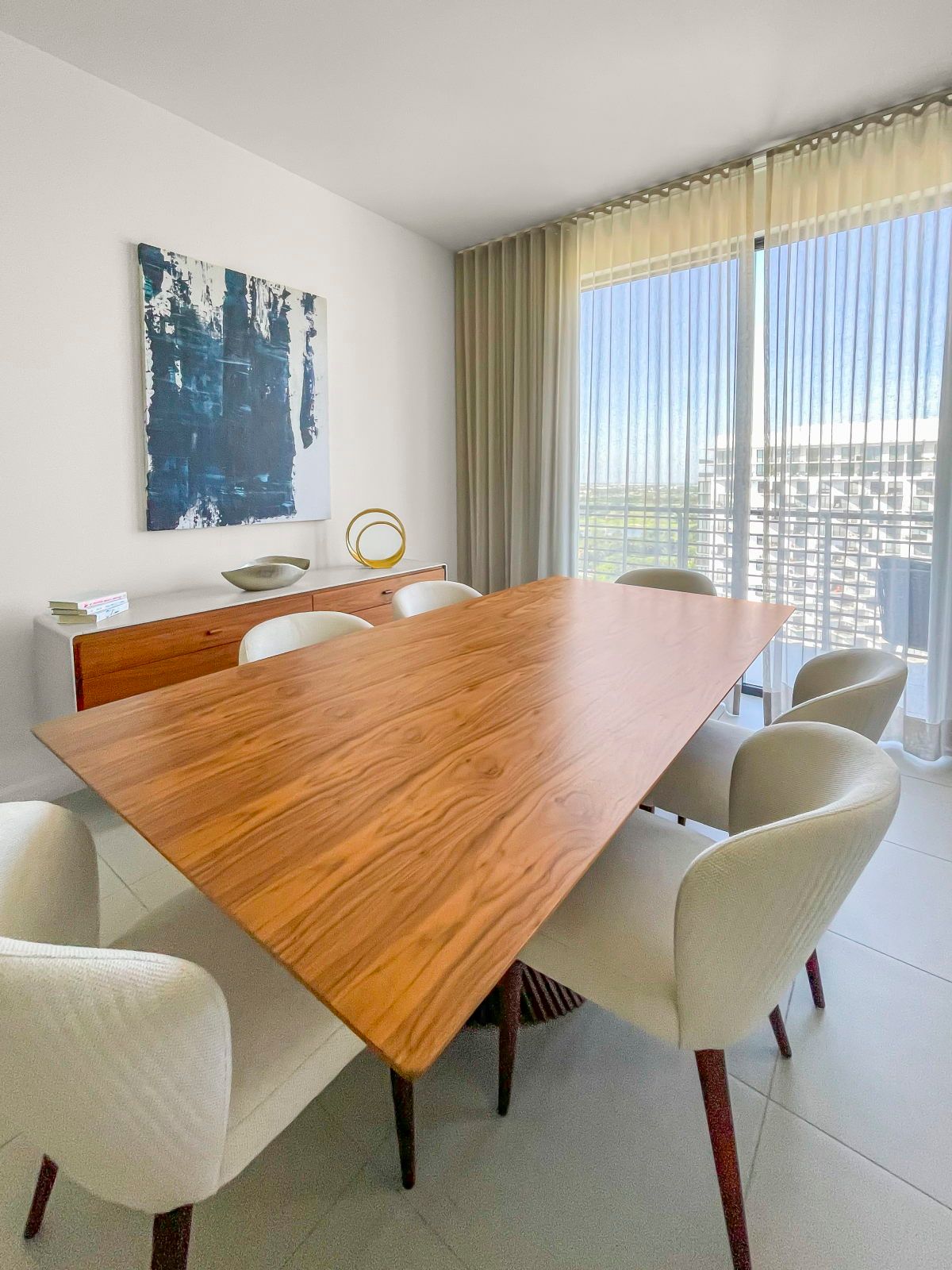 image Gather at this stylish dining table, bathed in natural light and accented by modern decor.