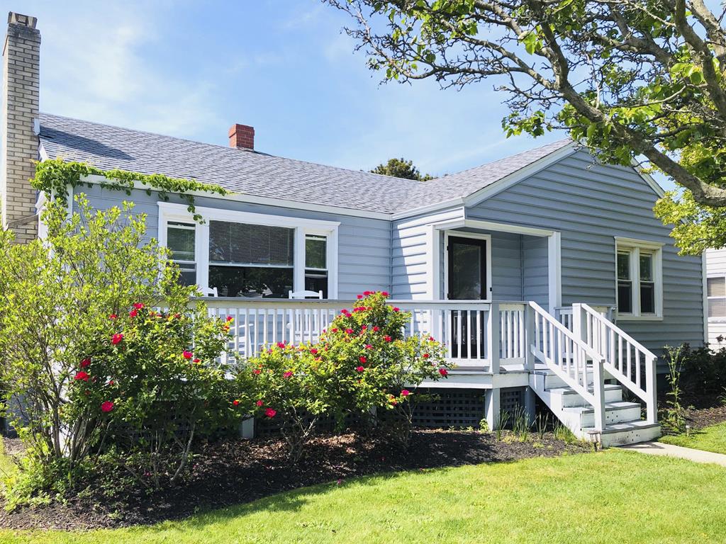image Step onto the welcoming front porch, surrounded by vibrant flowers and charming pathways.