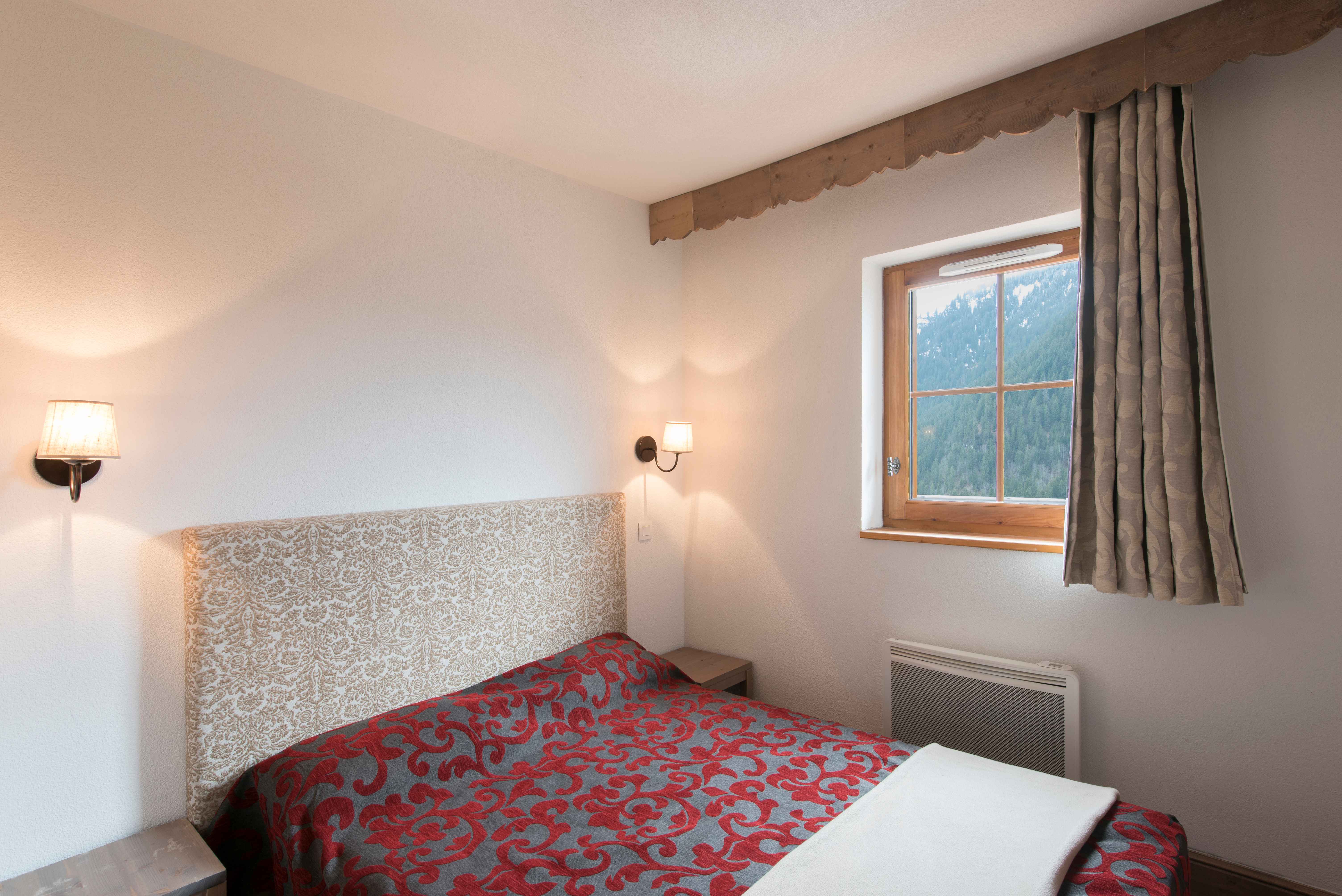 image A peaceful double bedroom, individually decorated in warm mountain tones — rest well and wake up ready for another alpine adventure.