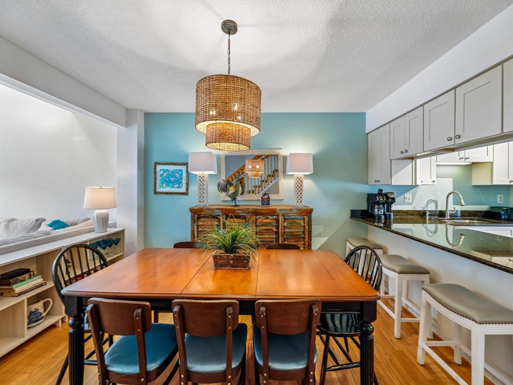 image Dining table and black chairs with the kitchen visible through the open-plan layout behind