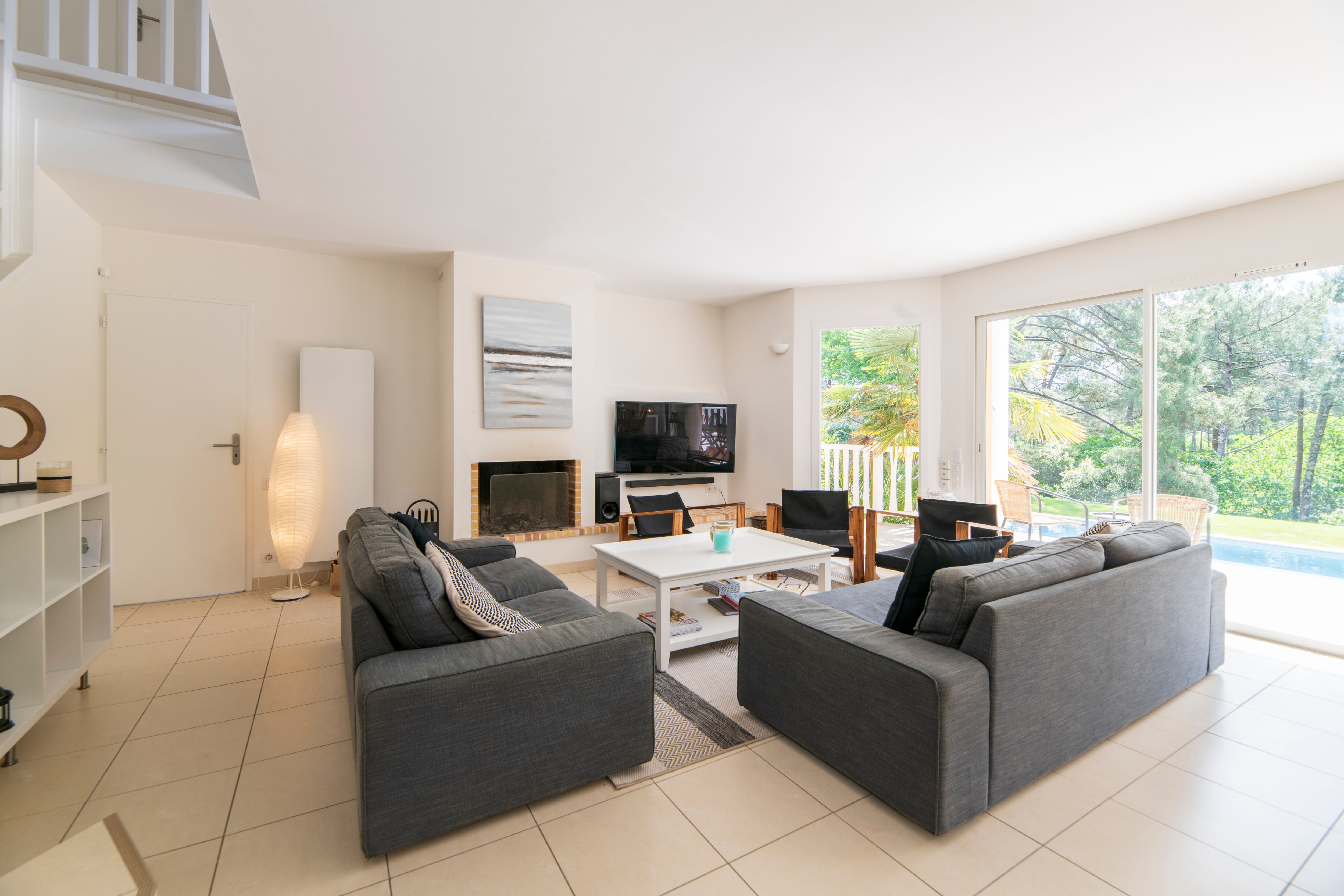 image Relax in the bright living room, where natural light pours in, inviting you to unwind by the pool.