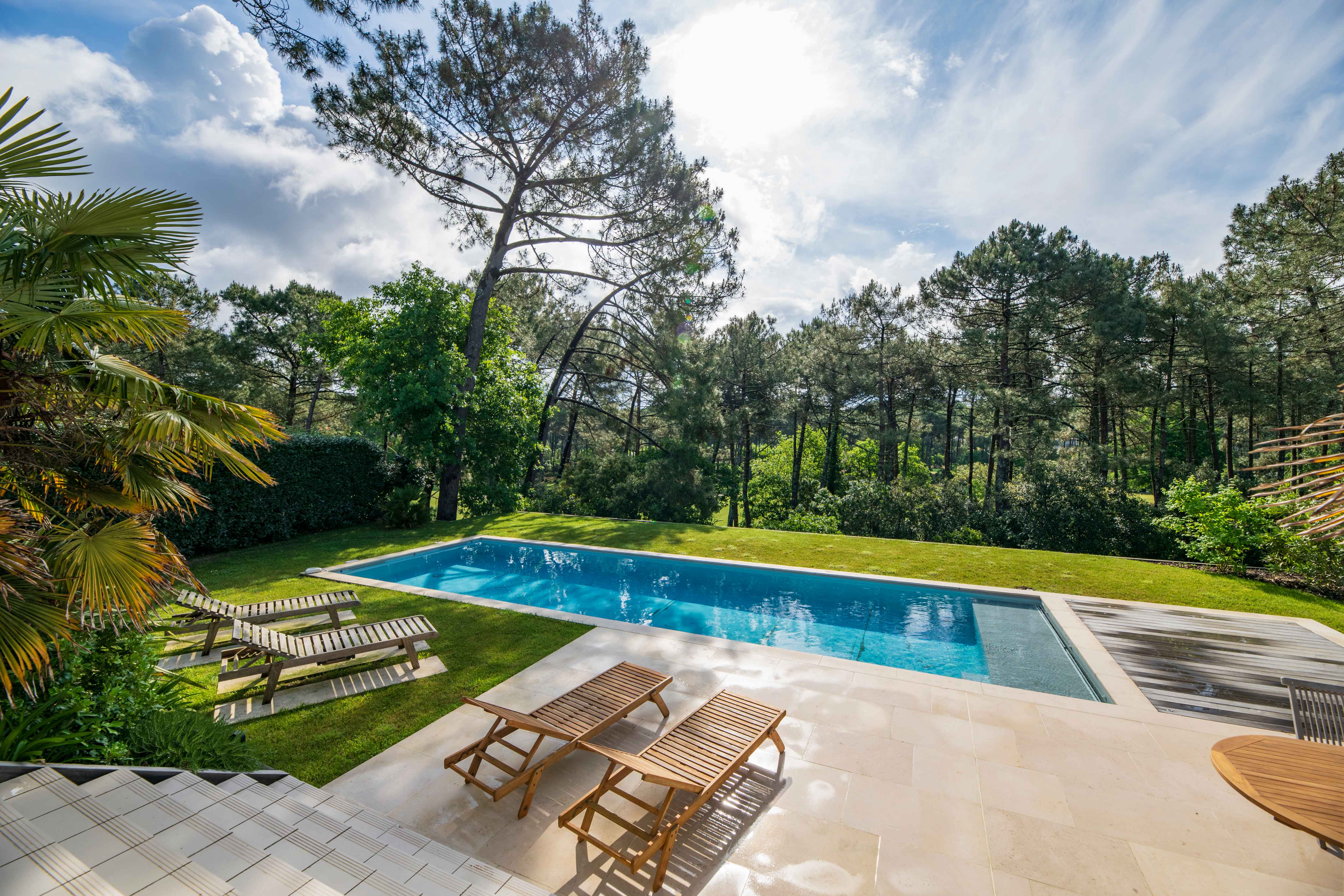 image Unwind by the pristine private pool, surrounded by lush greenery and dappled sunlight.