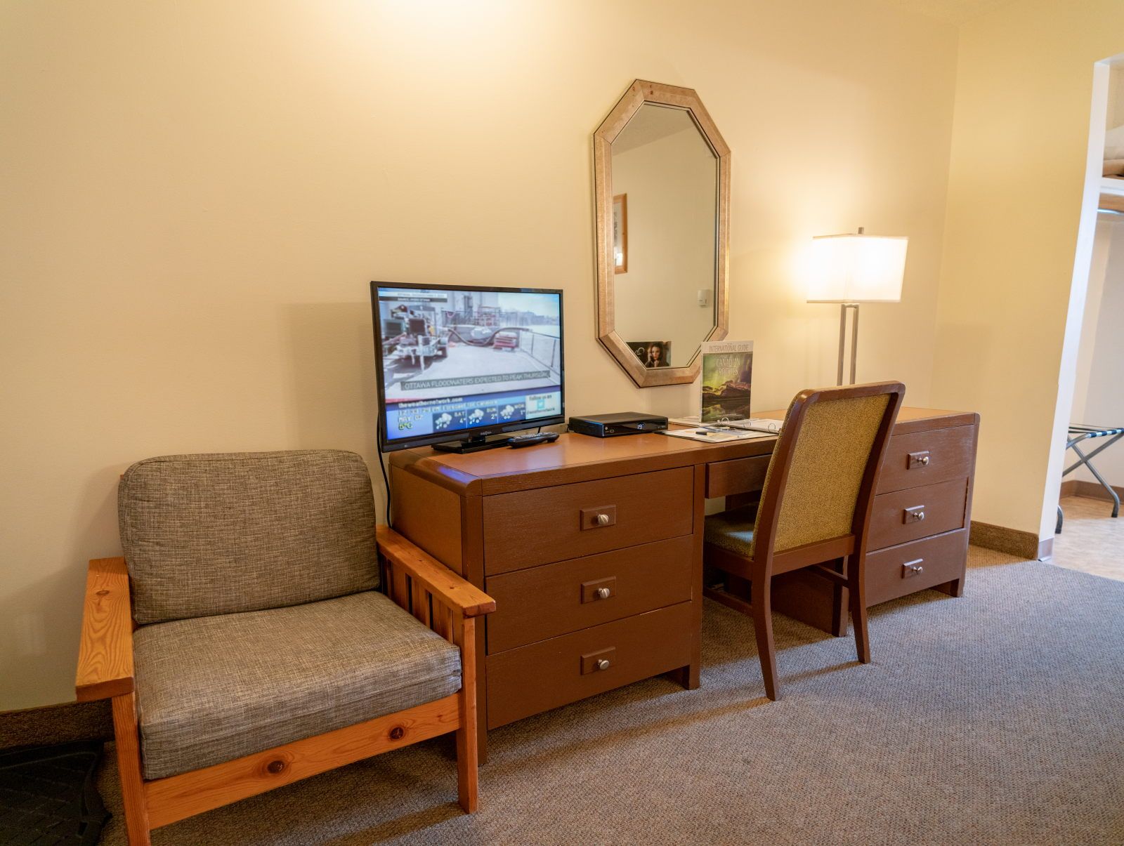 image Flat-screen TV, writing desk, and wooden chair fill out the living corner of the room