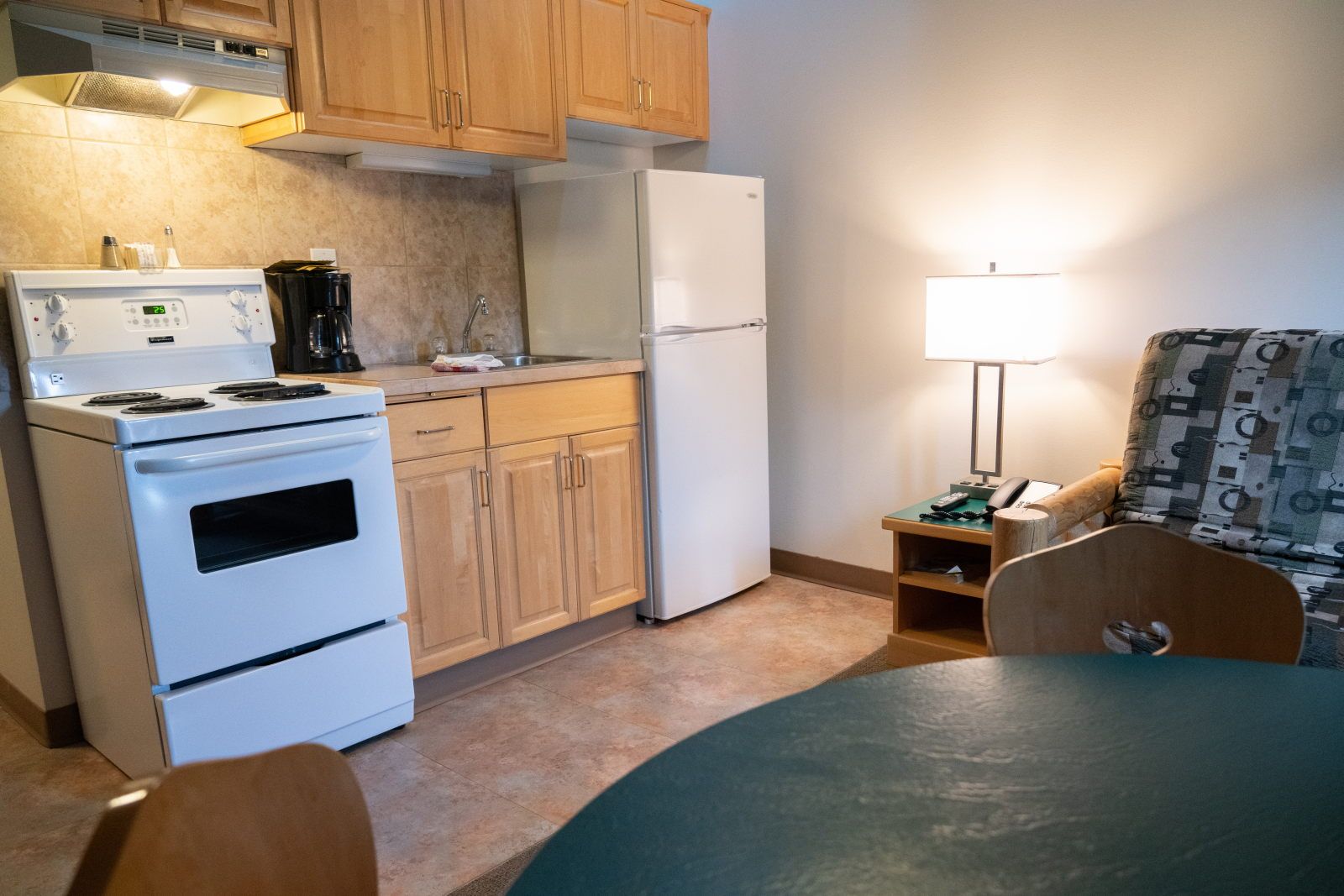 image Close-up of the kitchen counter: black-top stove, coffee maker, and sink with log-style seating nearby