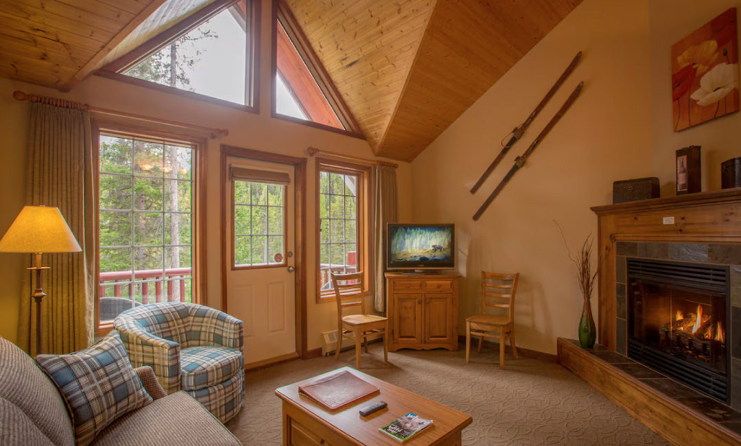 image Unwind in the living area beside a gas fireplace, surrounded by large windows letting in natural light.