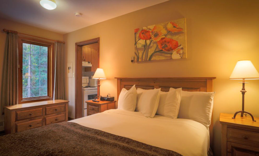 image Relax in a cozy bedroom featuring a queen-size bed and warm lighting, perfect for restful nights.