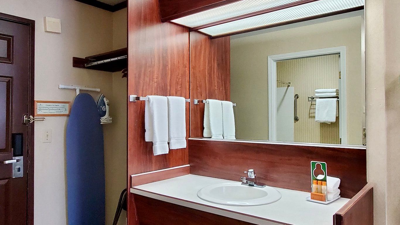 image Tub/shower combo and well-lit vanity with makeup mirror in the bathroom.
