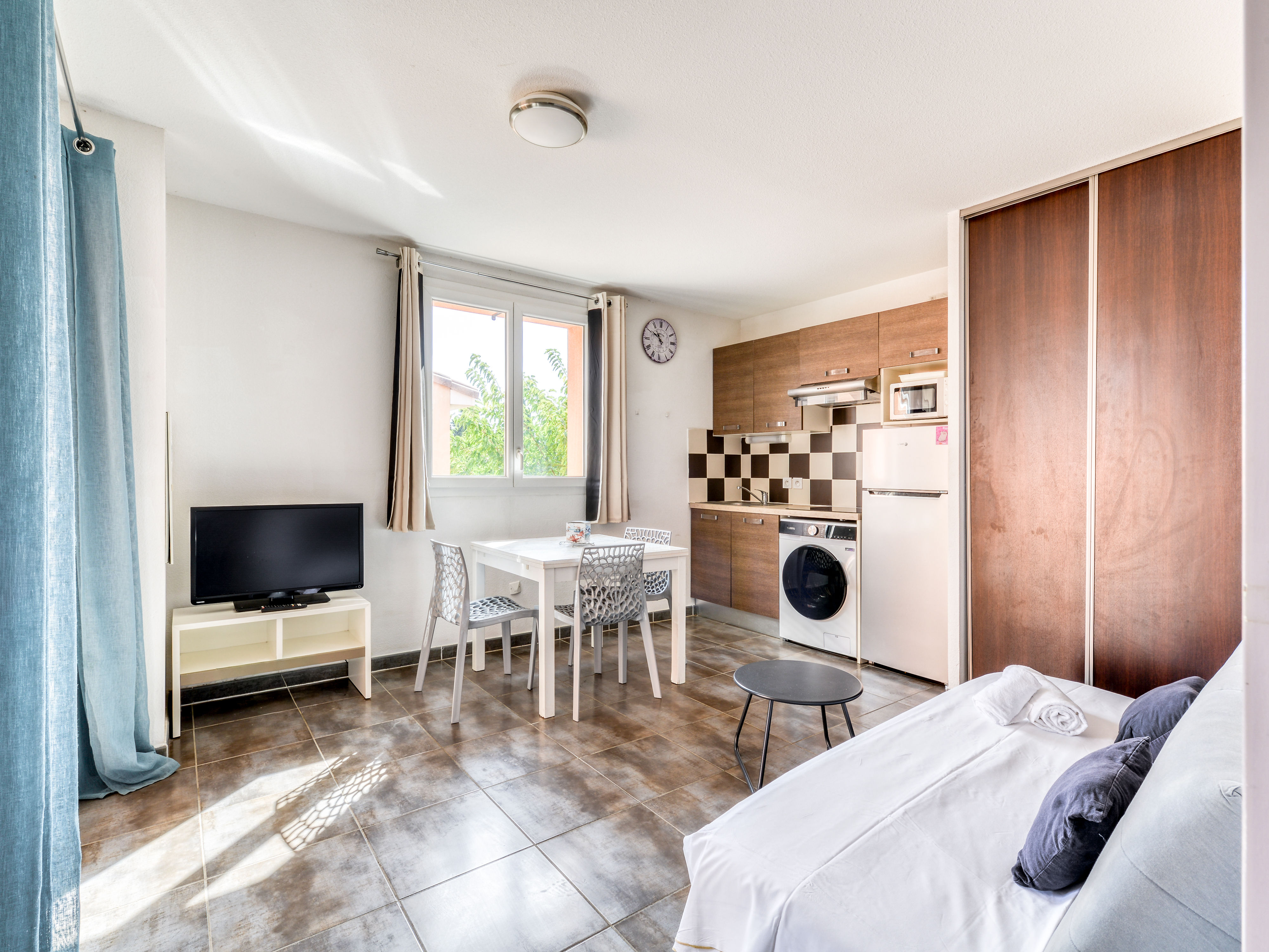 image Living area with flat-screen TV and convertible sofa that sleeps 2 — air conditioning keeps things cool after a day at the beach