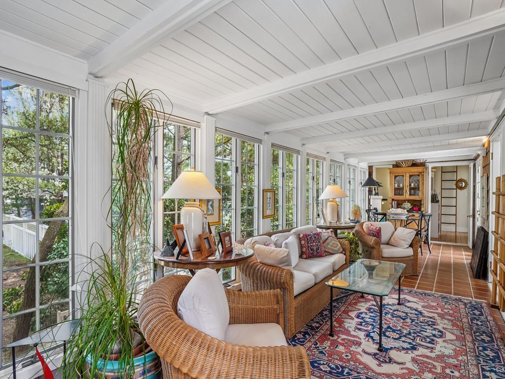 image Sun-drenched sun room with large windows, seating for the whole group, and a dining table for four