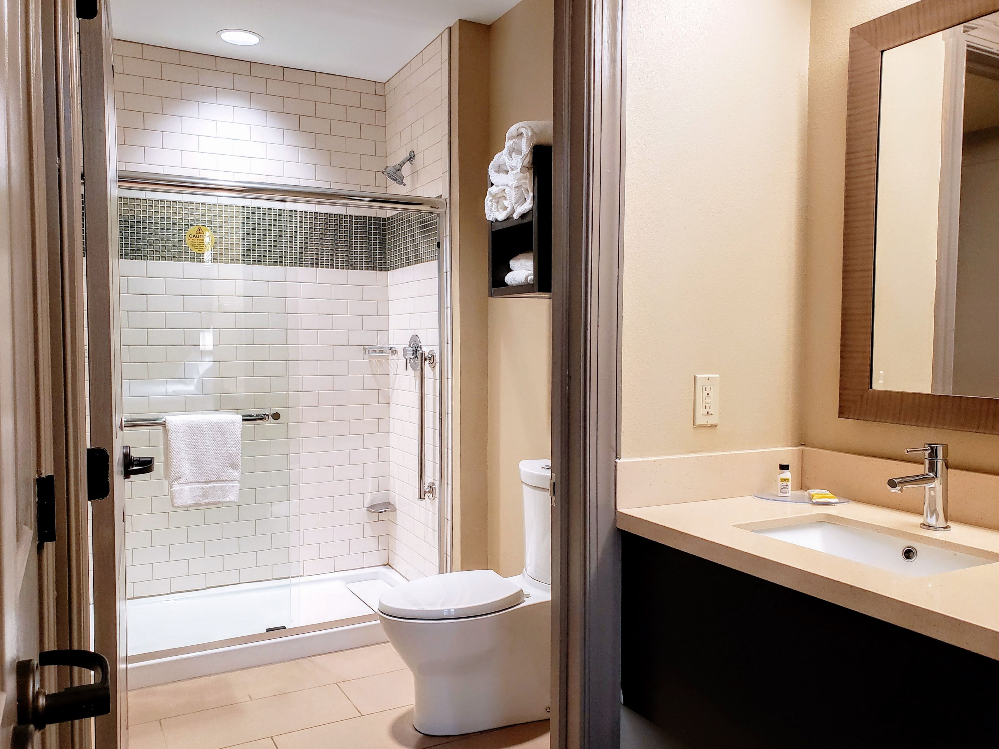 image Bright bathroom showcasing a glass shower and sleek countertop.
