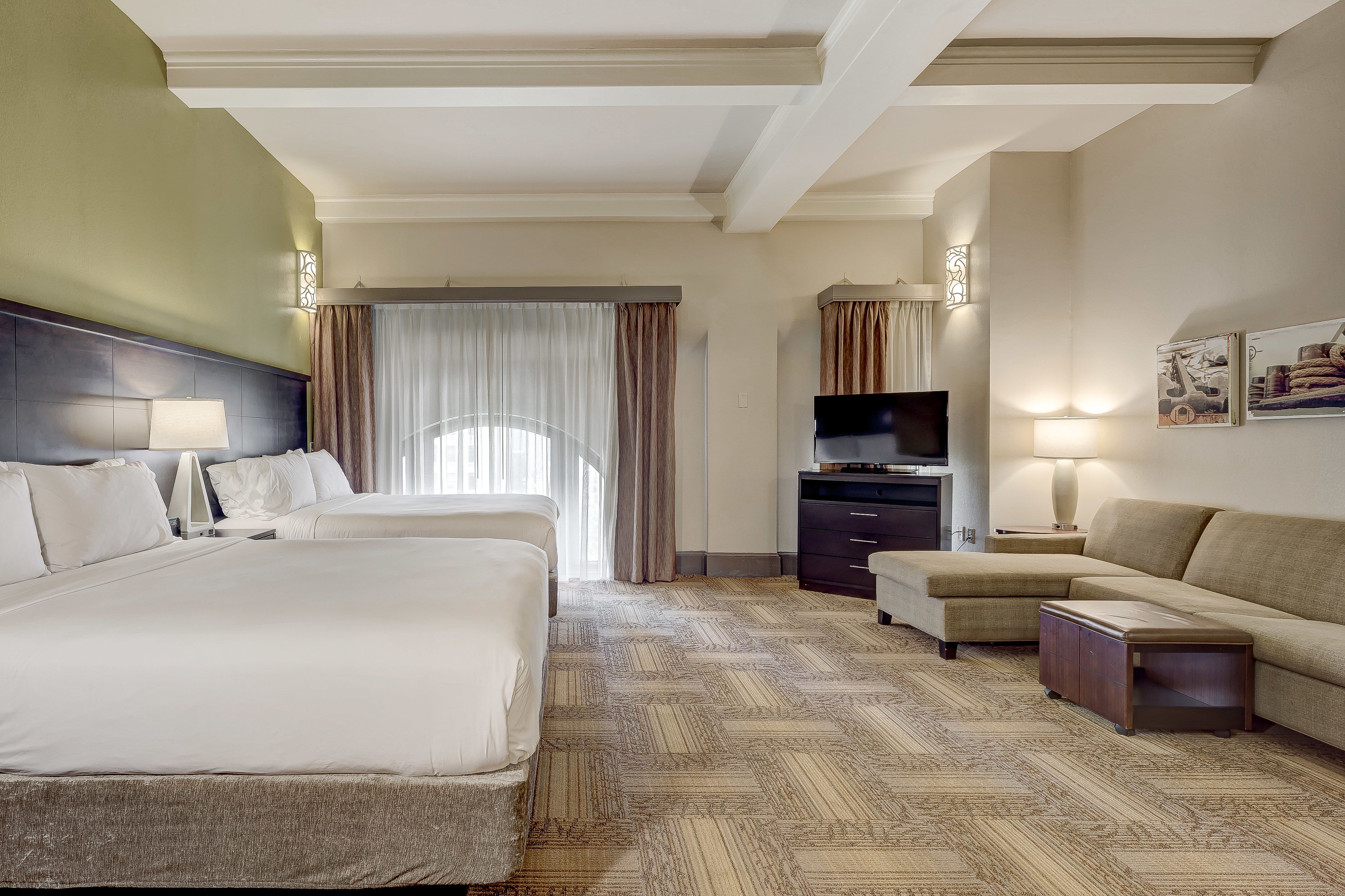 image Bright suite with large window, sitting area, and soft lighting.