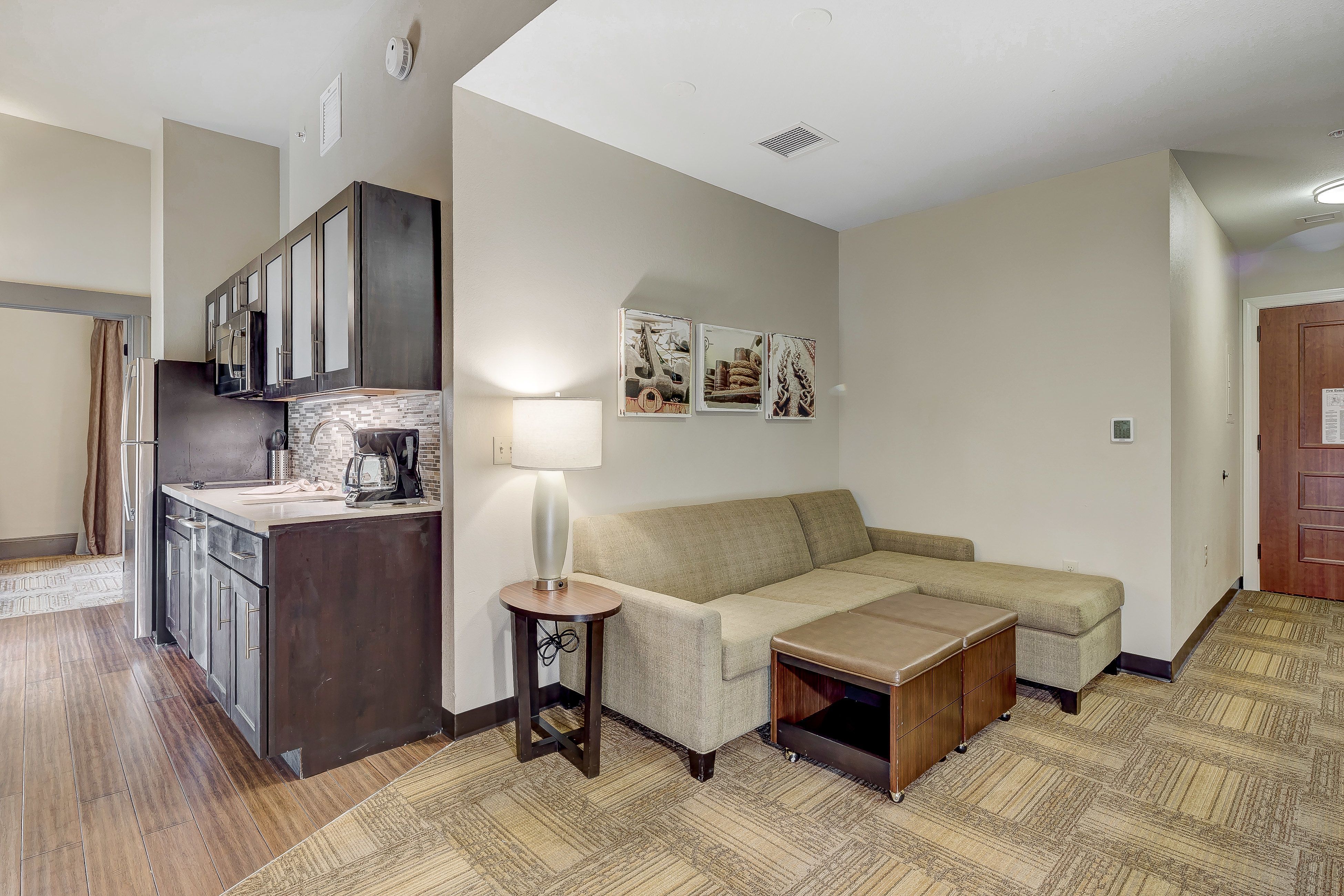 image Inviting living area with a comfortable couch and kitchenette.