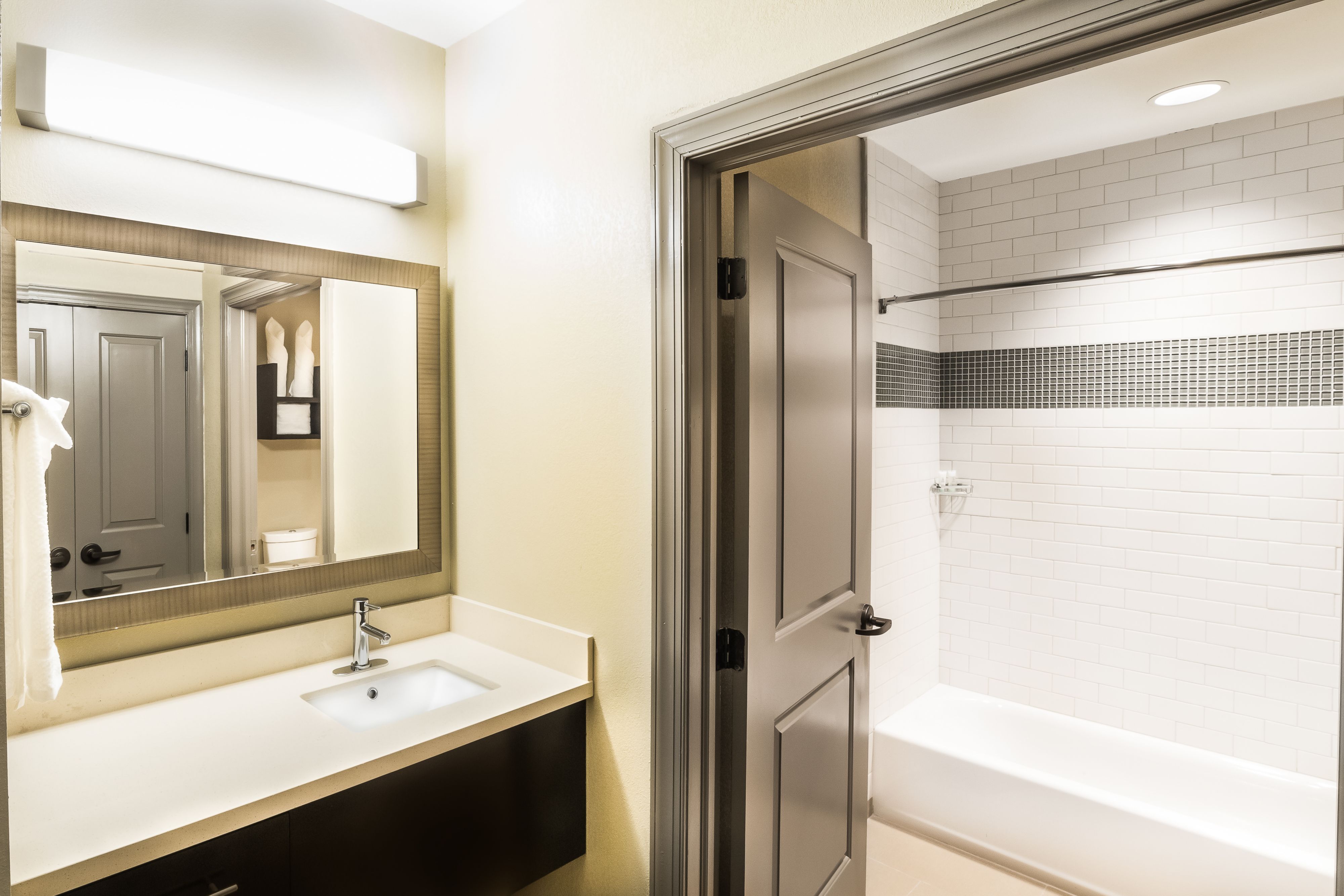 image Modern bathroom with sleek vanity and illuminated mirror.