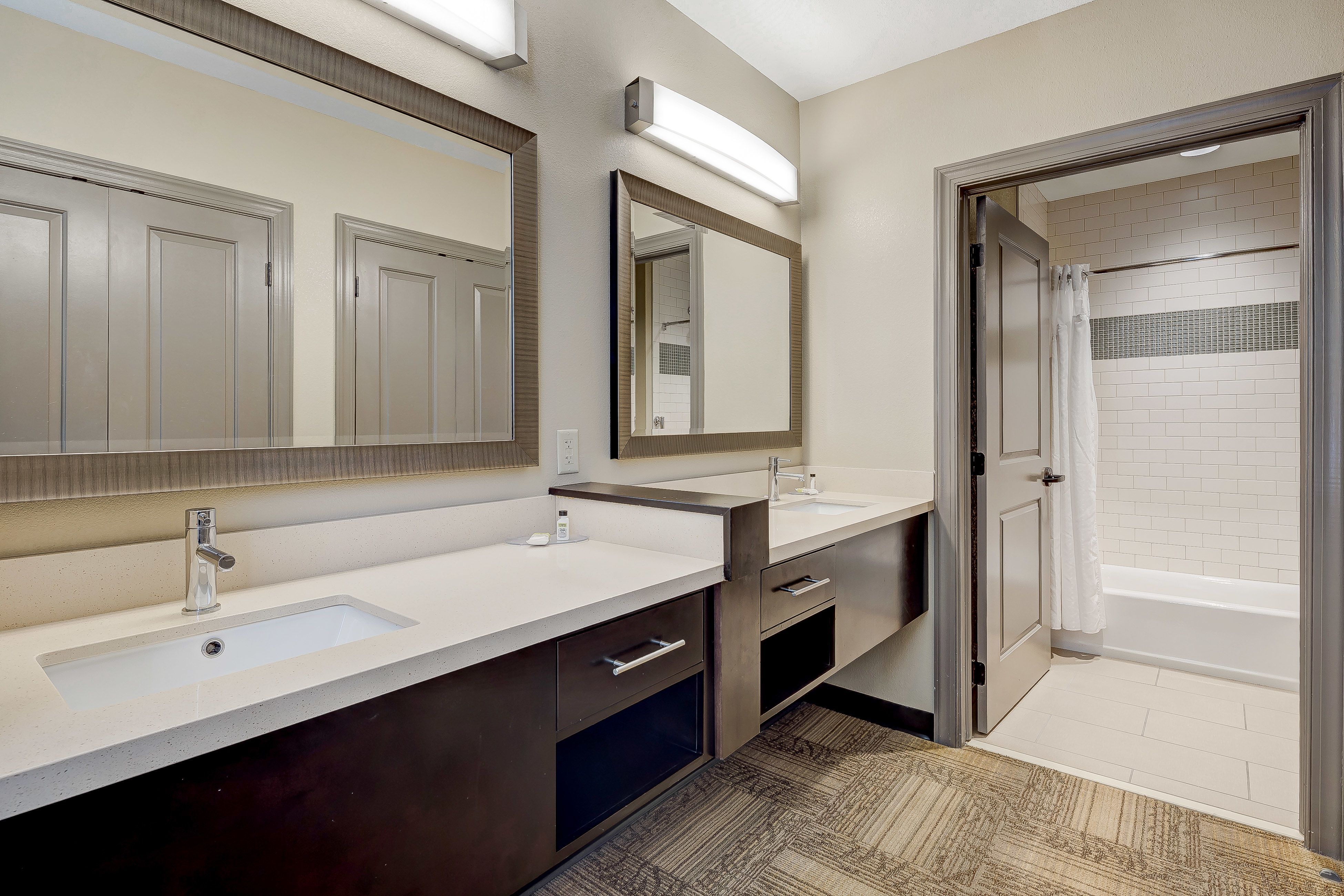 image Double sink bathroom with elegant mirrors and ample storage.