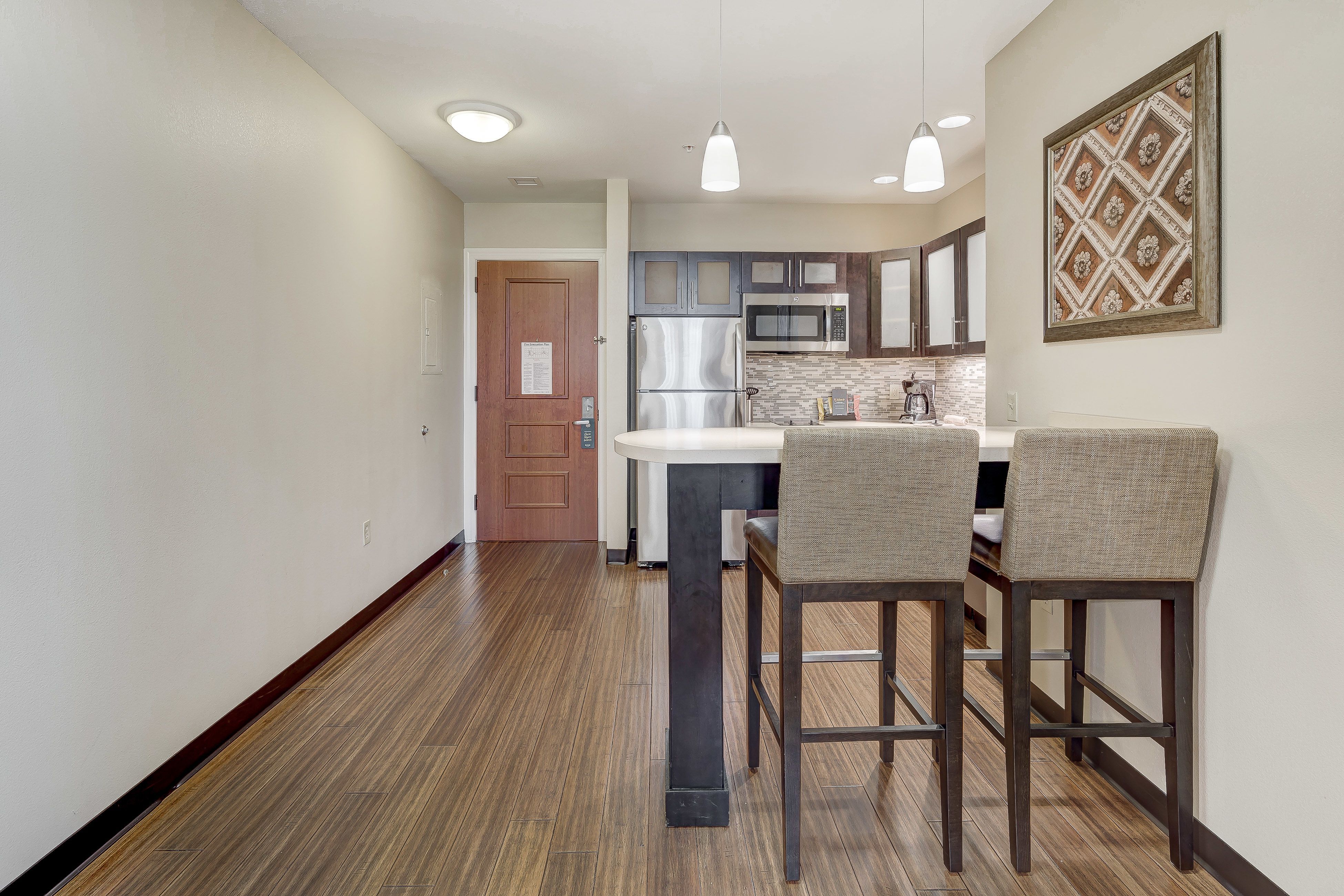 image Modern kitchen with stainless steel appliances and stylish bar seating.