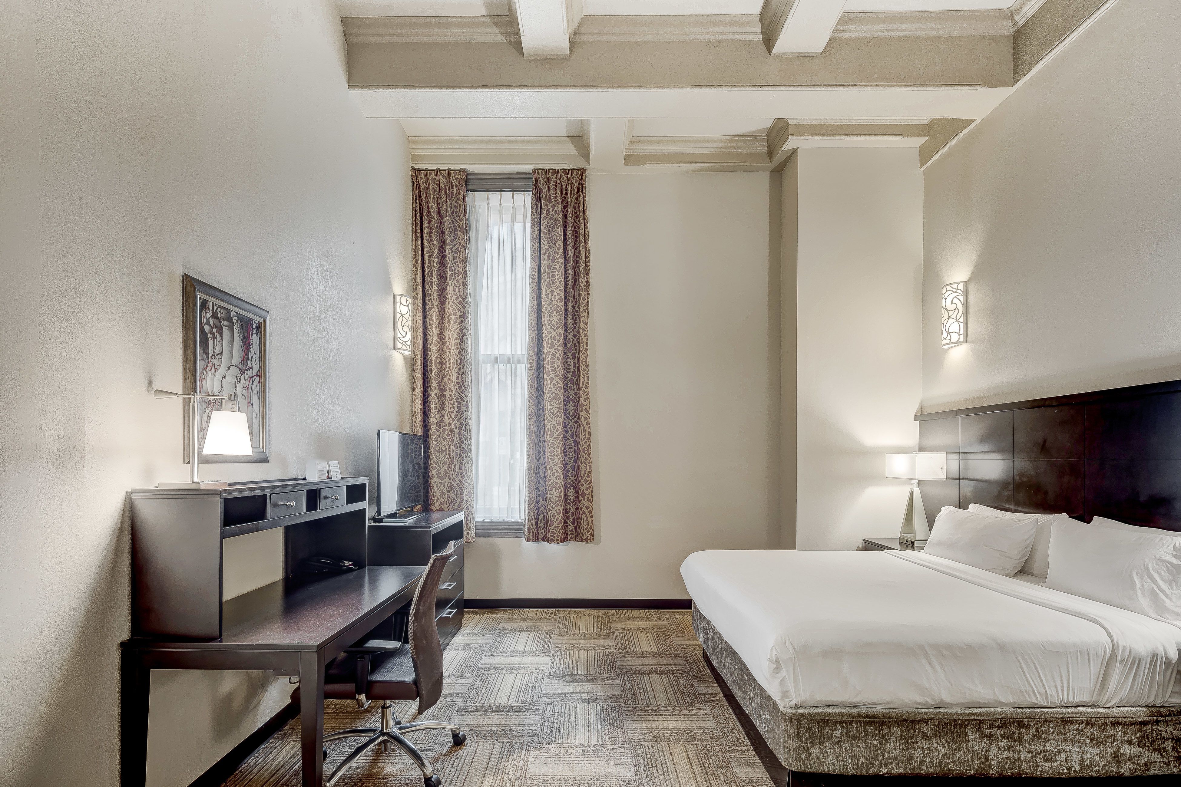 image Inviting bedroom equipped with a workspace and ample light.