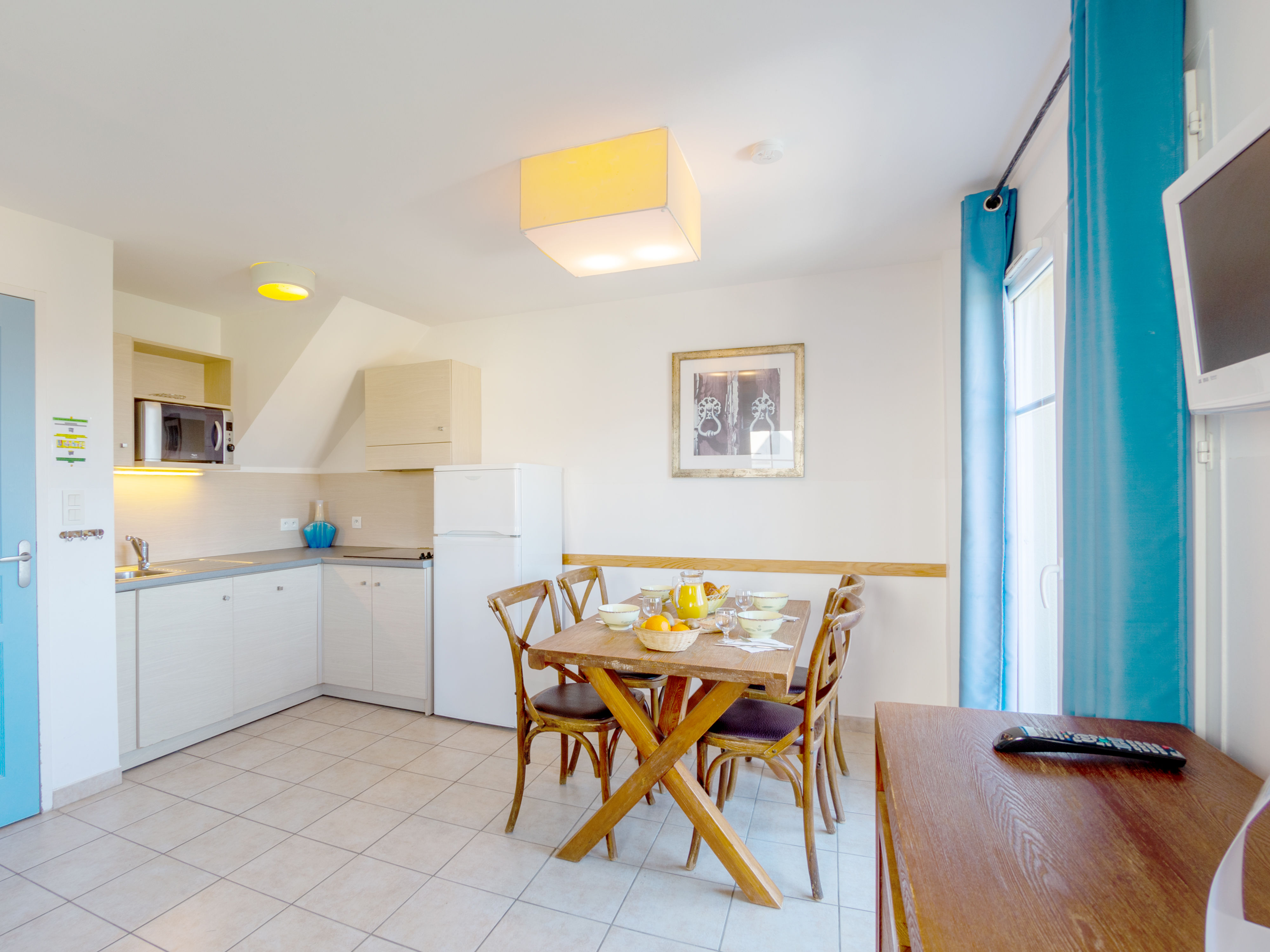 image Open-plan living space with double sofa bed and TV — the terrace door opens straight out to the sea view