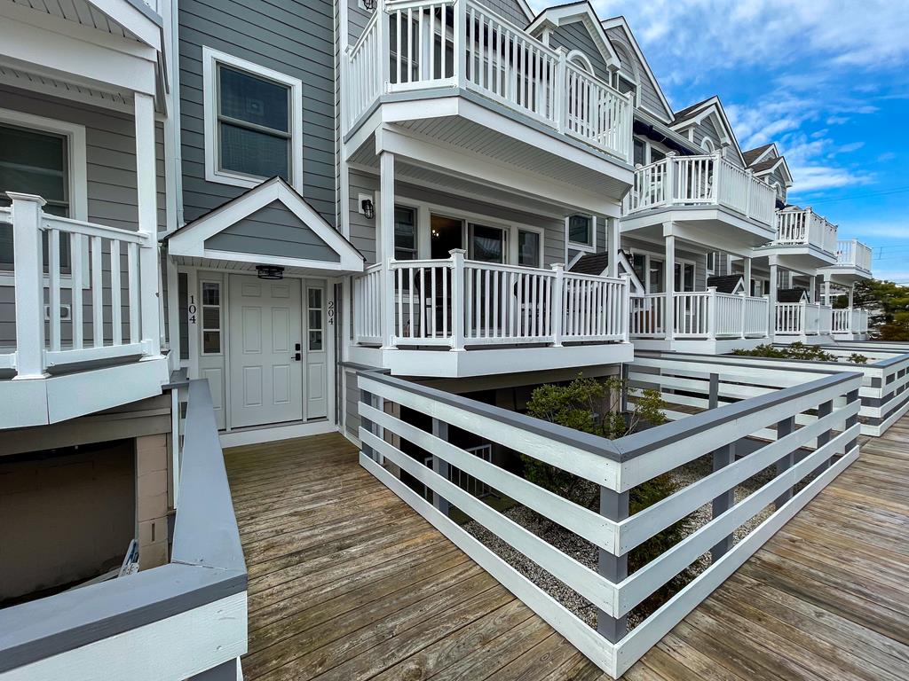 image Exterior of the building with private balconies and wooden decking — your home base in Cape May's Marina District.