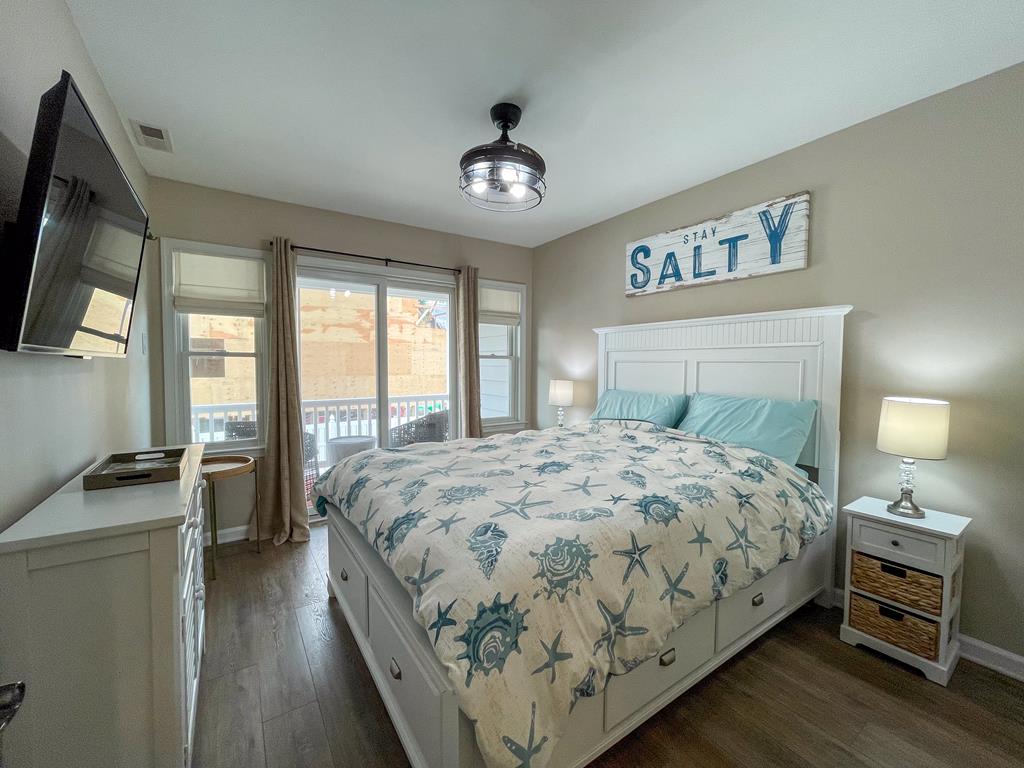 image King-size bed with crisp white linens and coastal bedding — the master bedroom is ready for a restful night.