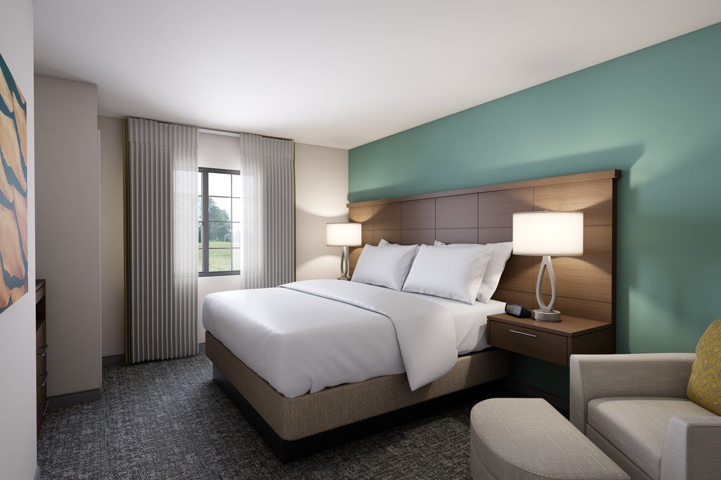 image King bedroom with lowered closet bar and flat-screen TV.