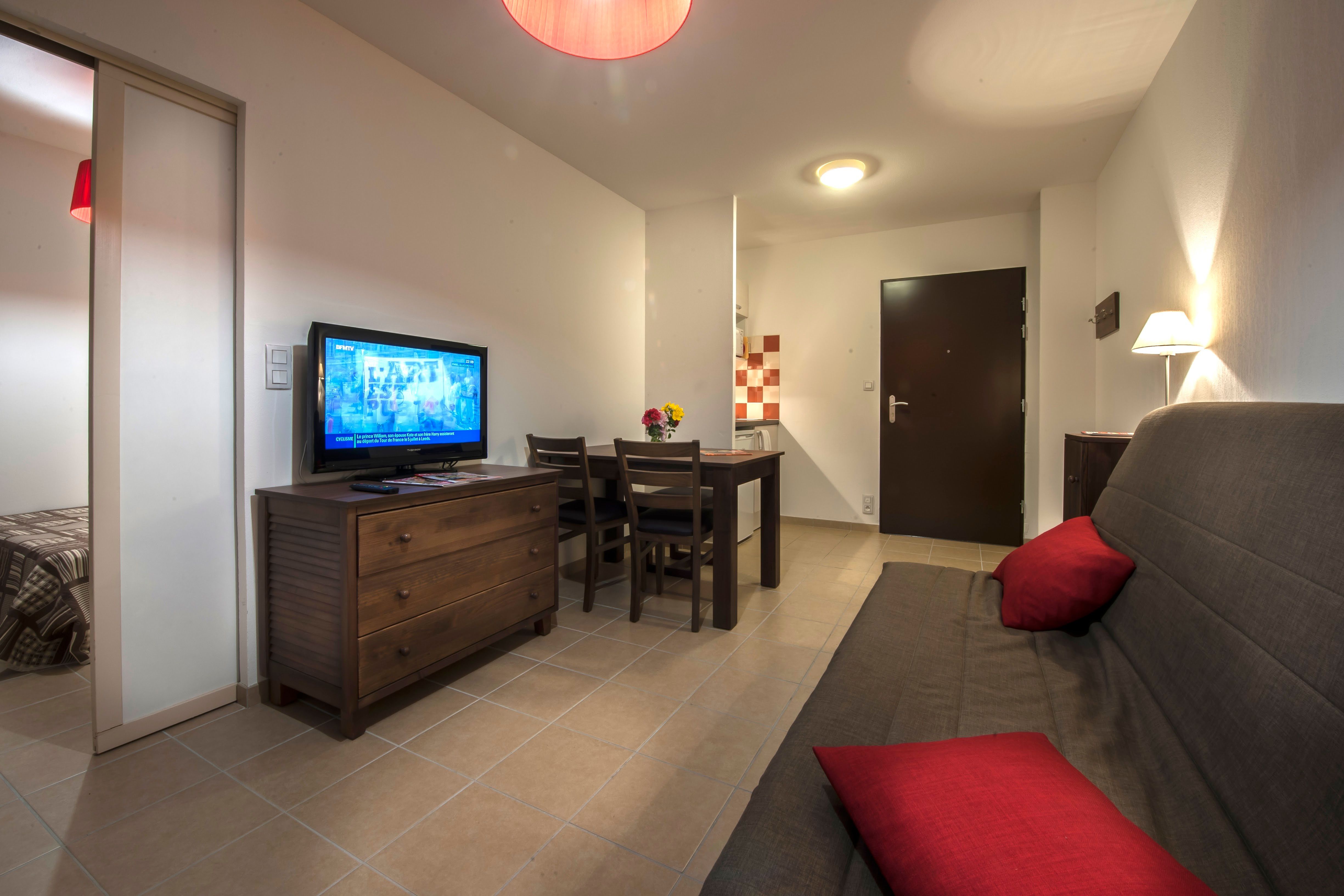 image Double sofa bed and flat-screen TV in the living area — step straight out to the furnished terrace from here