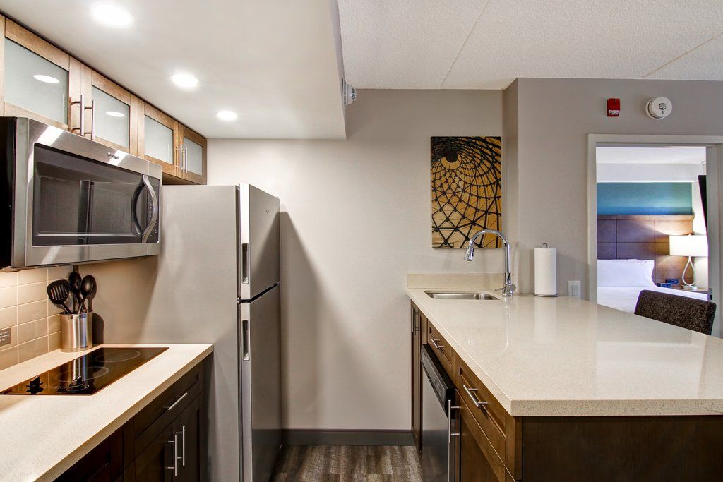 image Long kitchen counter with a tiled backsplash and recessed lighting — stainless steel appliances and full cookware included for self-catering stays.