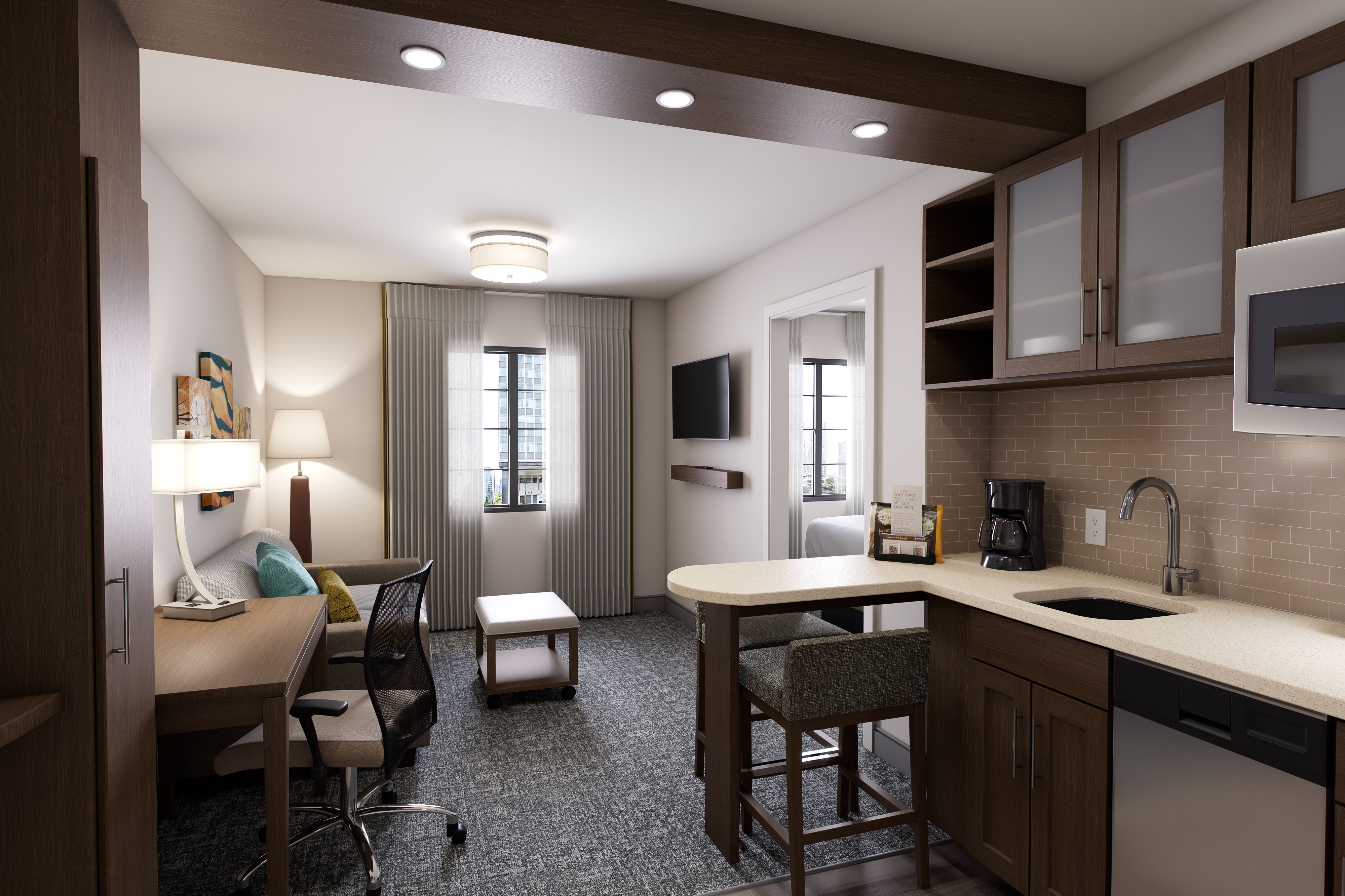 image Functional living room equipped with workspace and kitchen details.