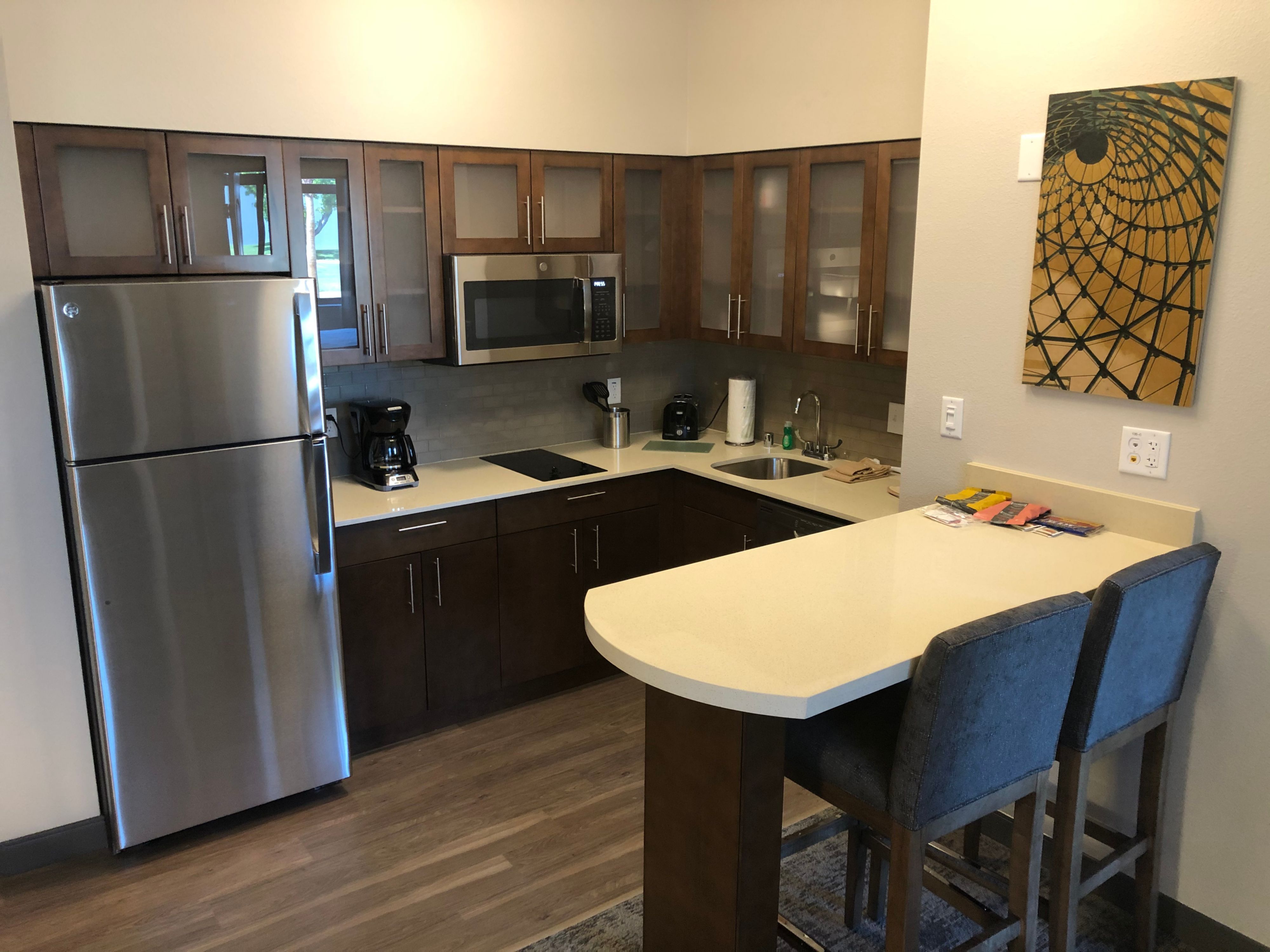 image Modern kitchen equipped with stainless steel appliances and seating.