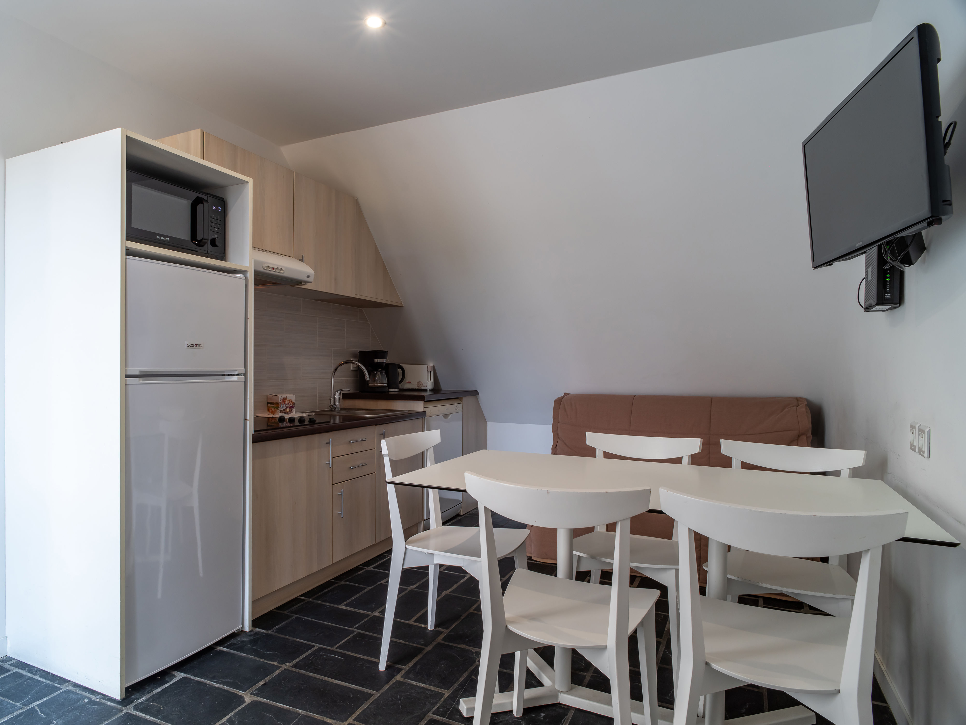 image Open-plan living area with a sofa and flat-screen TV, steps from the furnished terrace