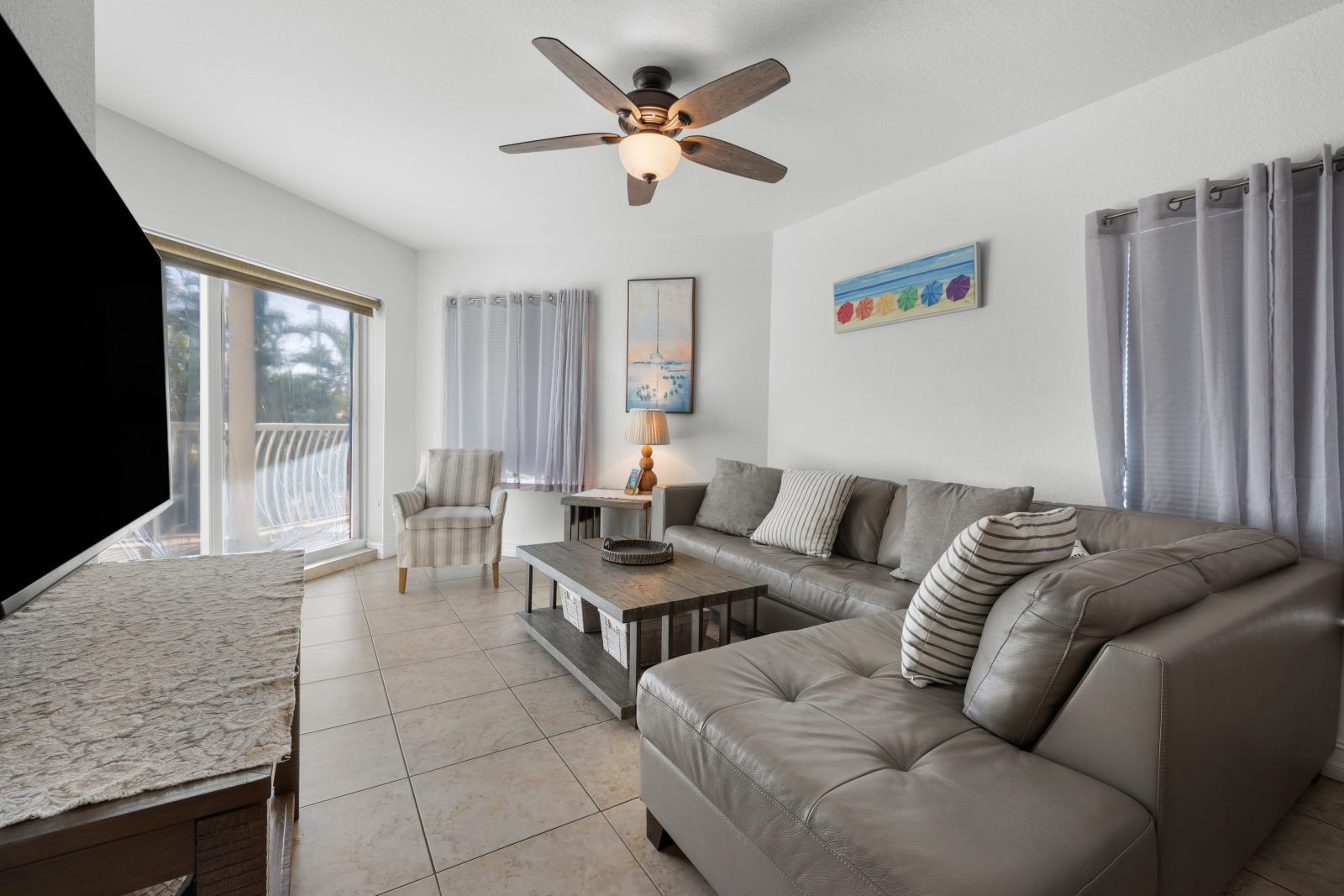 image Relax in the bright living space, complete with cozy seating and natural light.