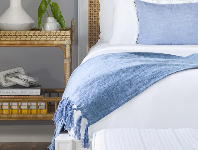 image King bed with layered textiles and handwoven rattan accents — your private retreat after a day on the championship courses