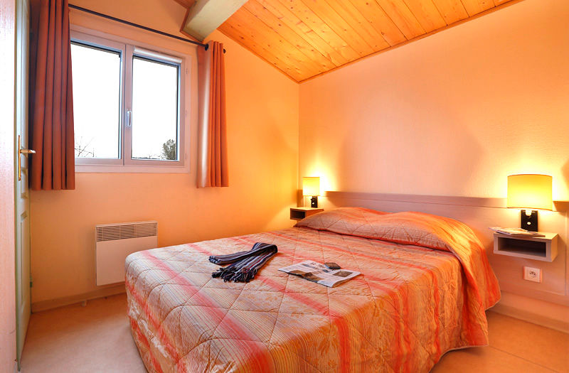 image Double bed with soft white linens — one of two bedrooms in this 57m² house for six