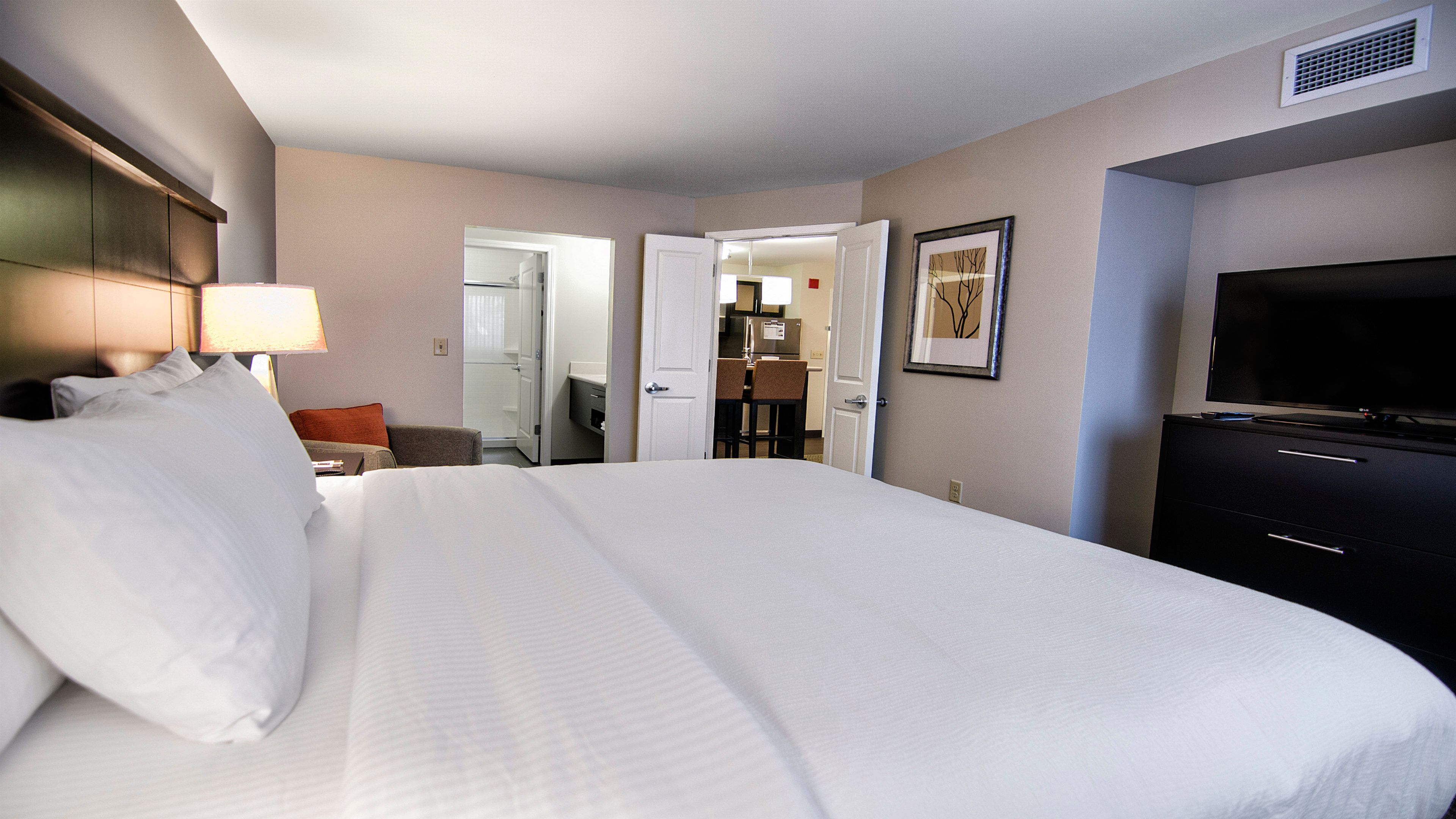 image Private bedroom with king bed, crisp white linens, and bedside lamp.