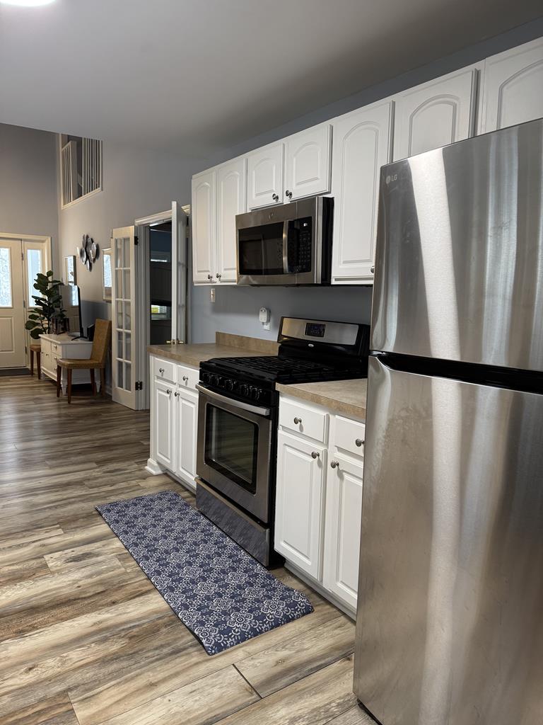 image Clean white cabinetry and open shelving keep the kitchen bright and easy to navigate