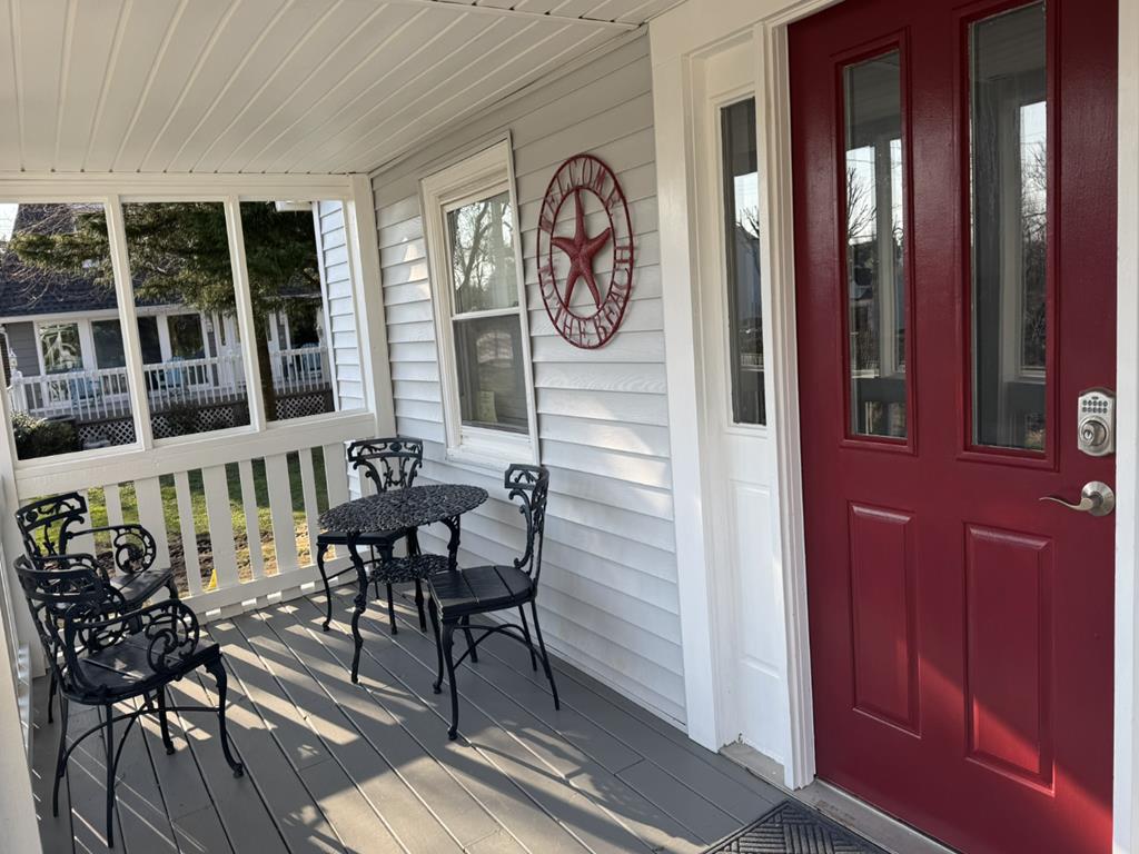 image Screened-in front porch with table and chairs — a shaded spot to start the morning before heading to the beach