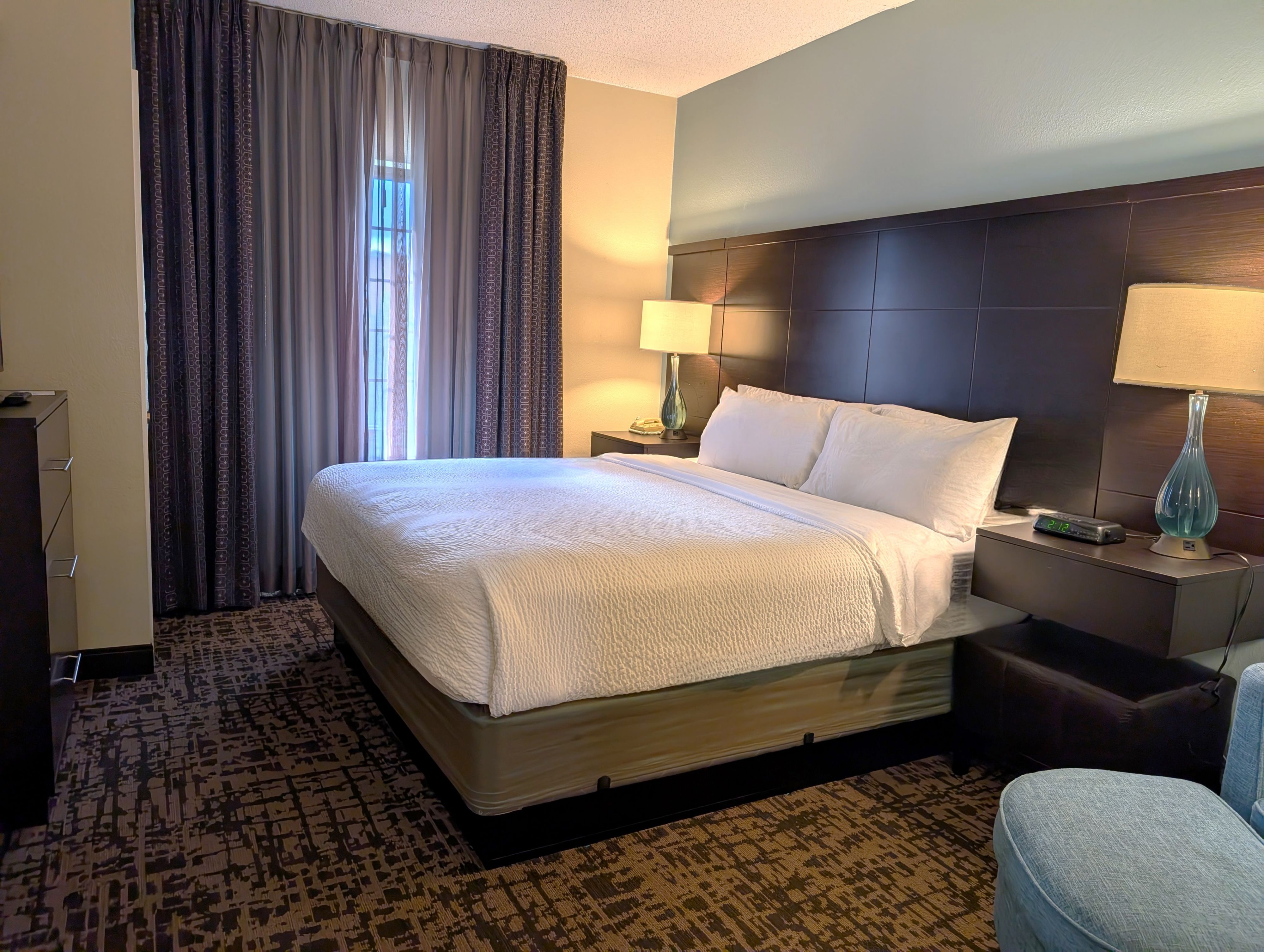 image Bright bedroom with bedside lamps and ample natural light.