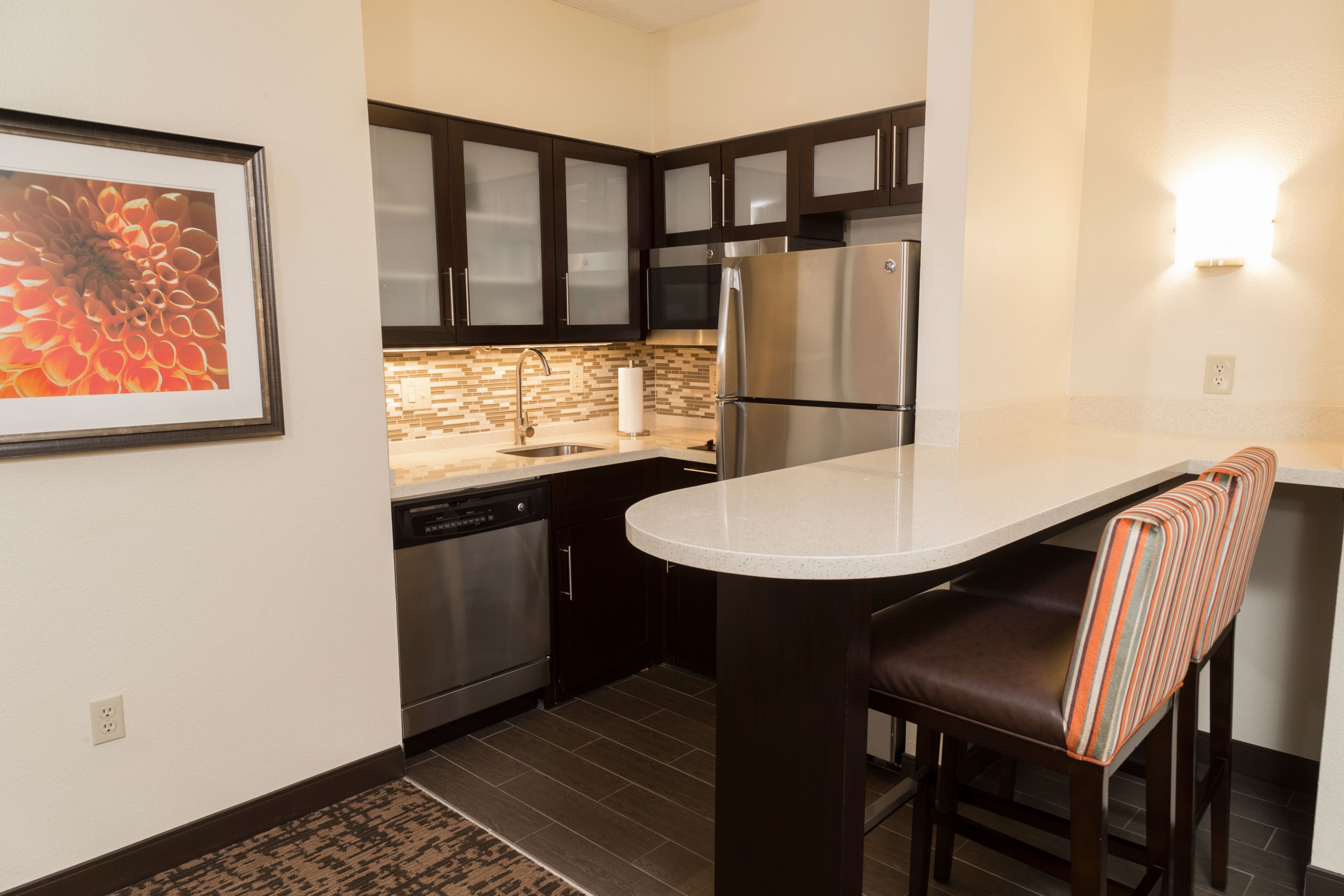 image Fully equipped kitchen with stainless steel appliances and bar seating.
