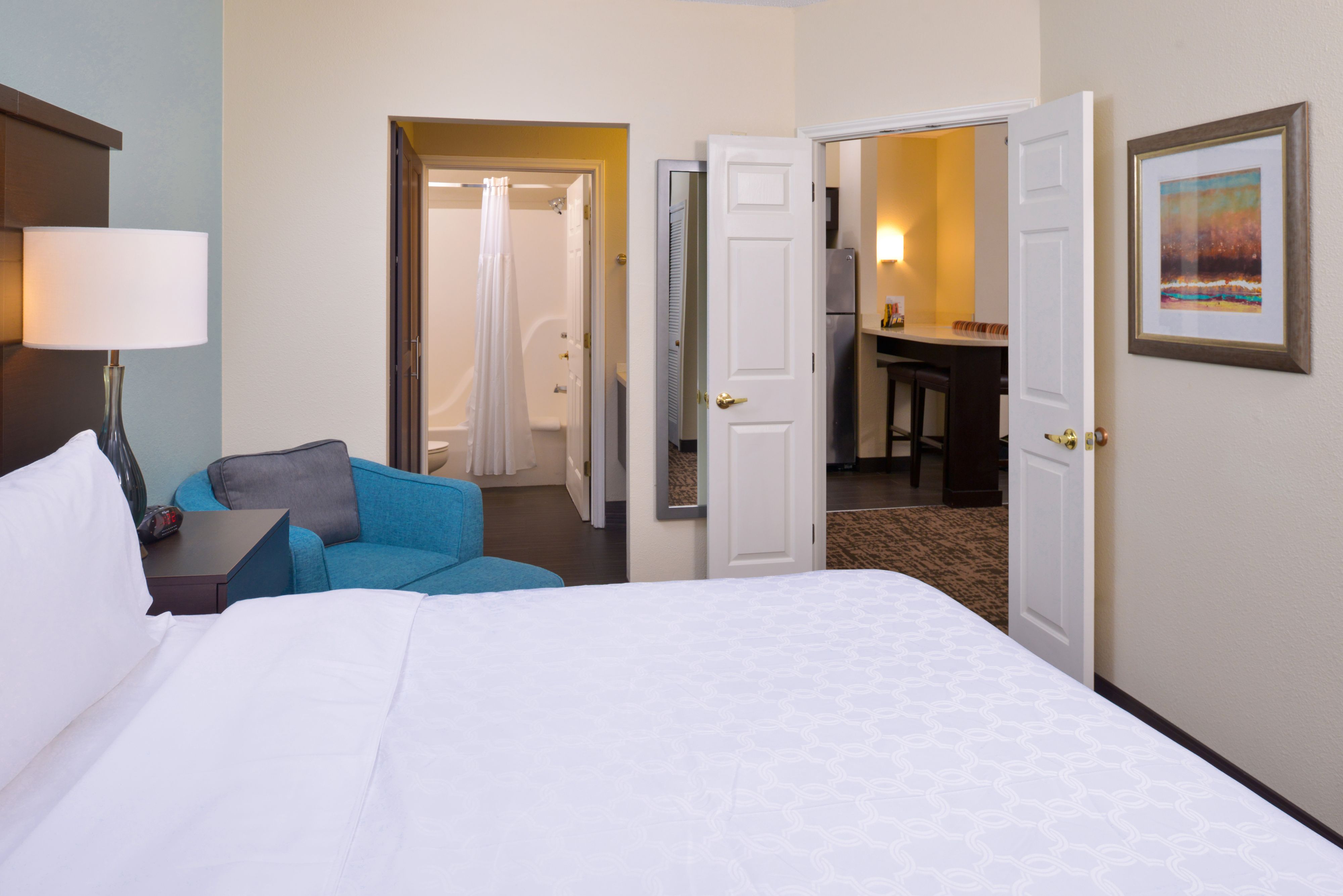 image Bedroom with attached bathroom and kitchen visible.