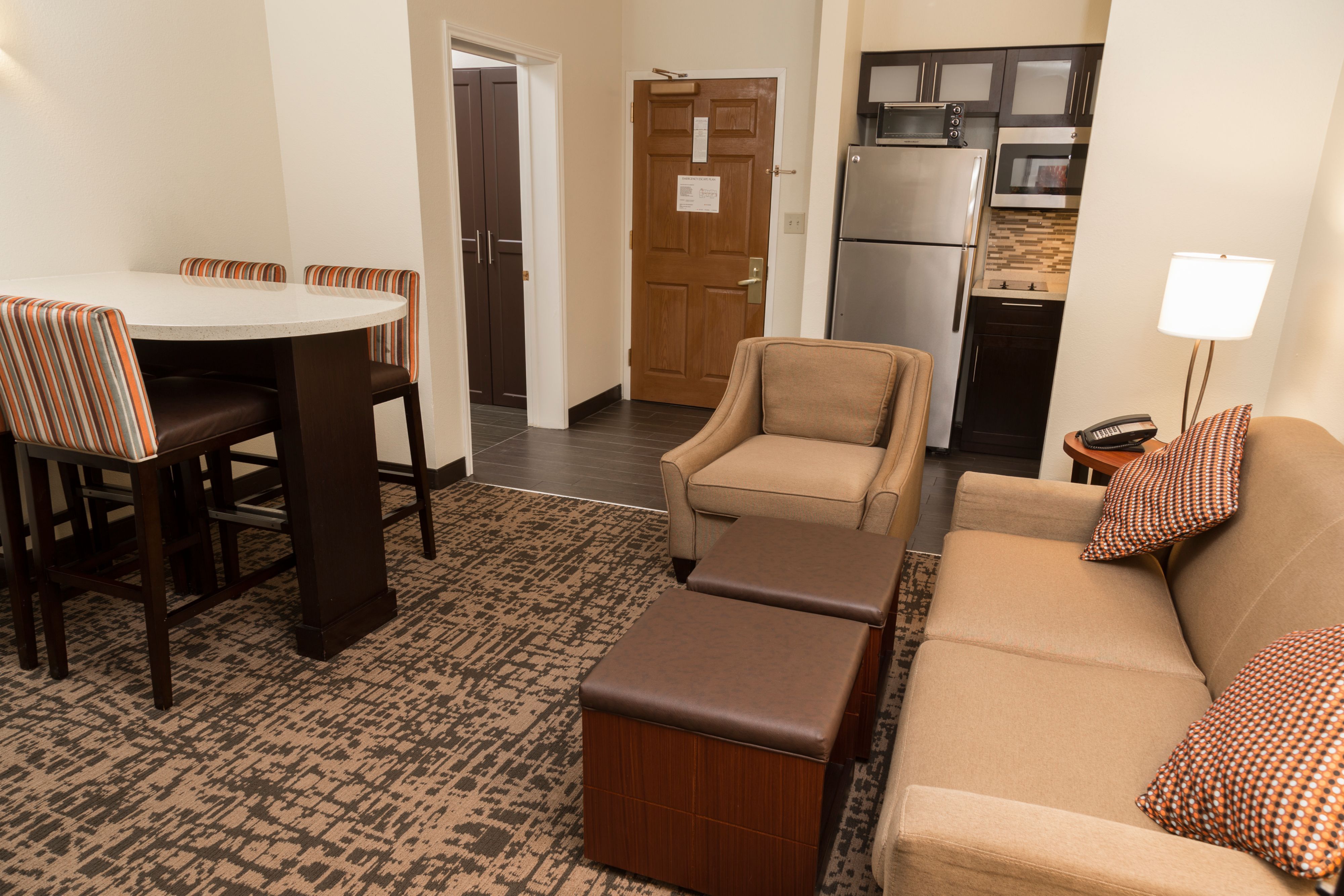 image Comfortable living area with decorative pillows and kitchen access.