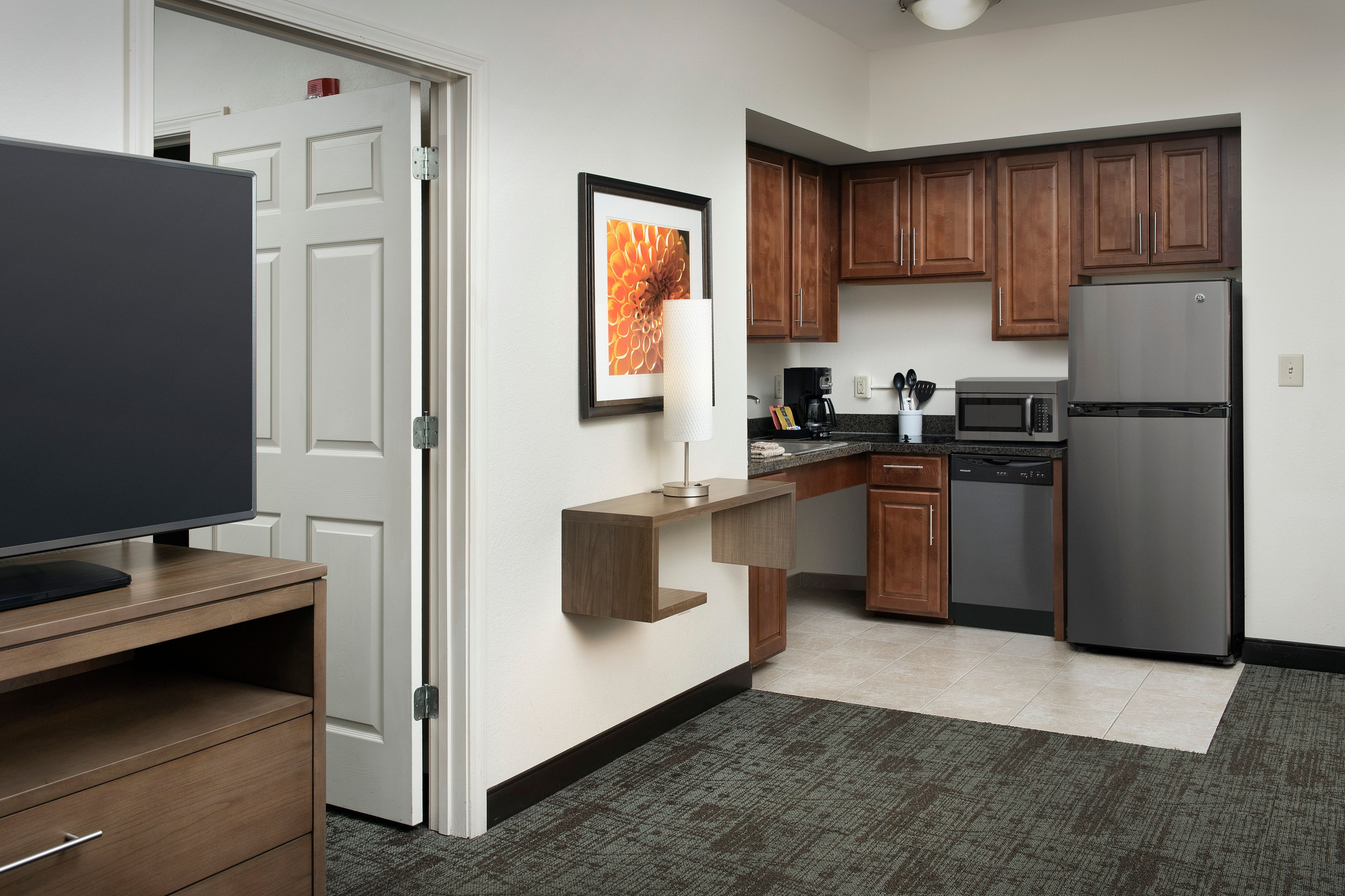 image Fully equipped kitchen with modern appliances and wooden cabinets.
