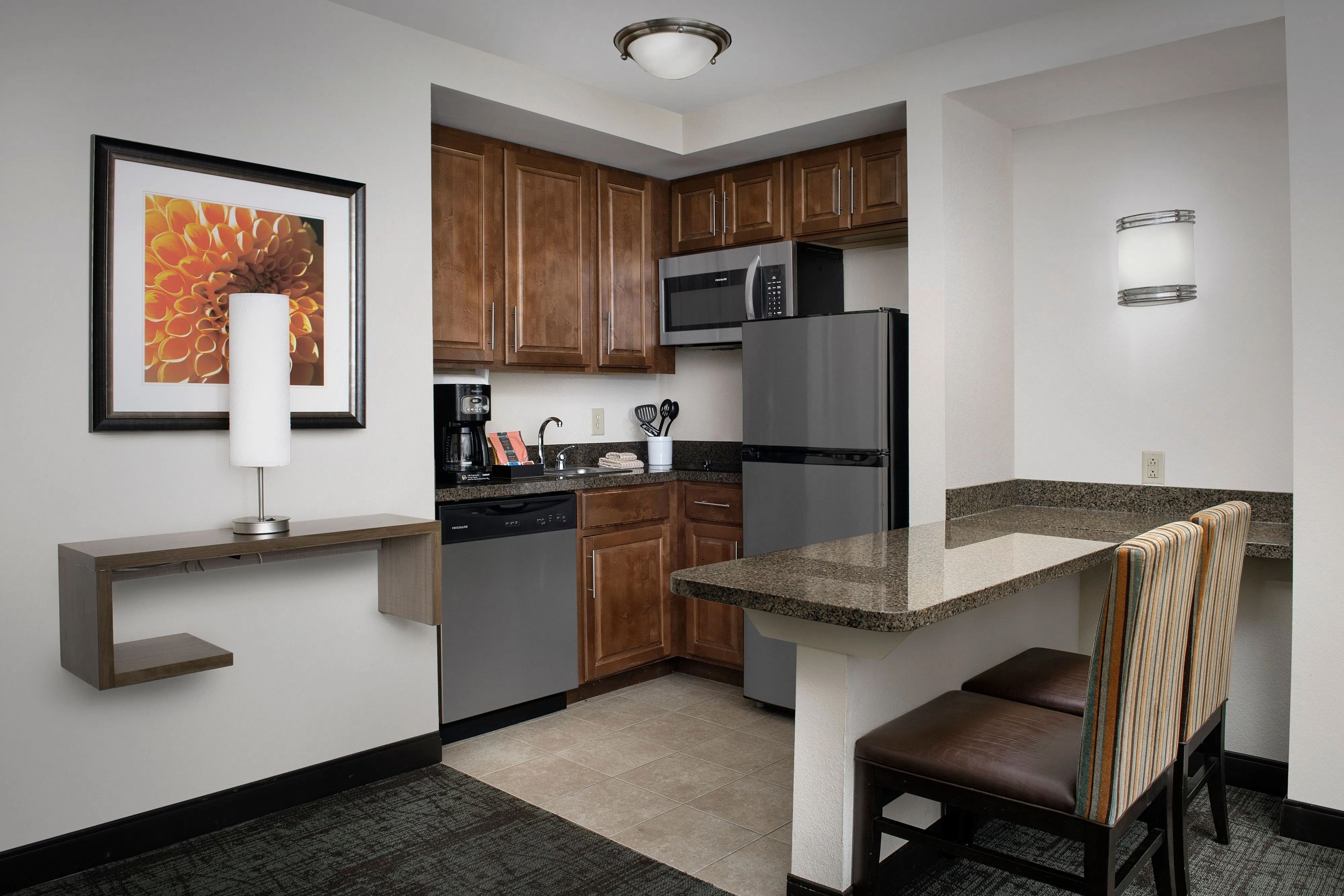 image Kitchen with appliances, counter, and seating for two.