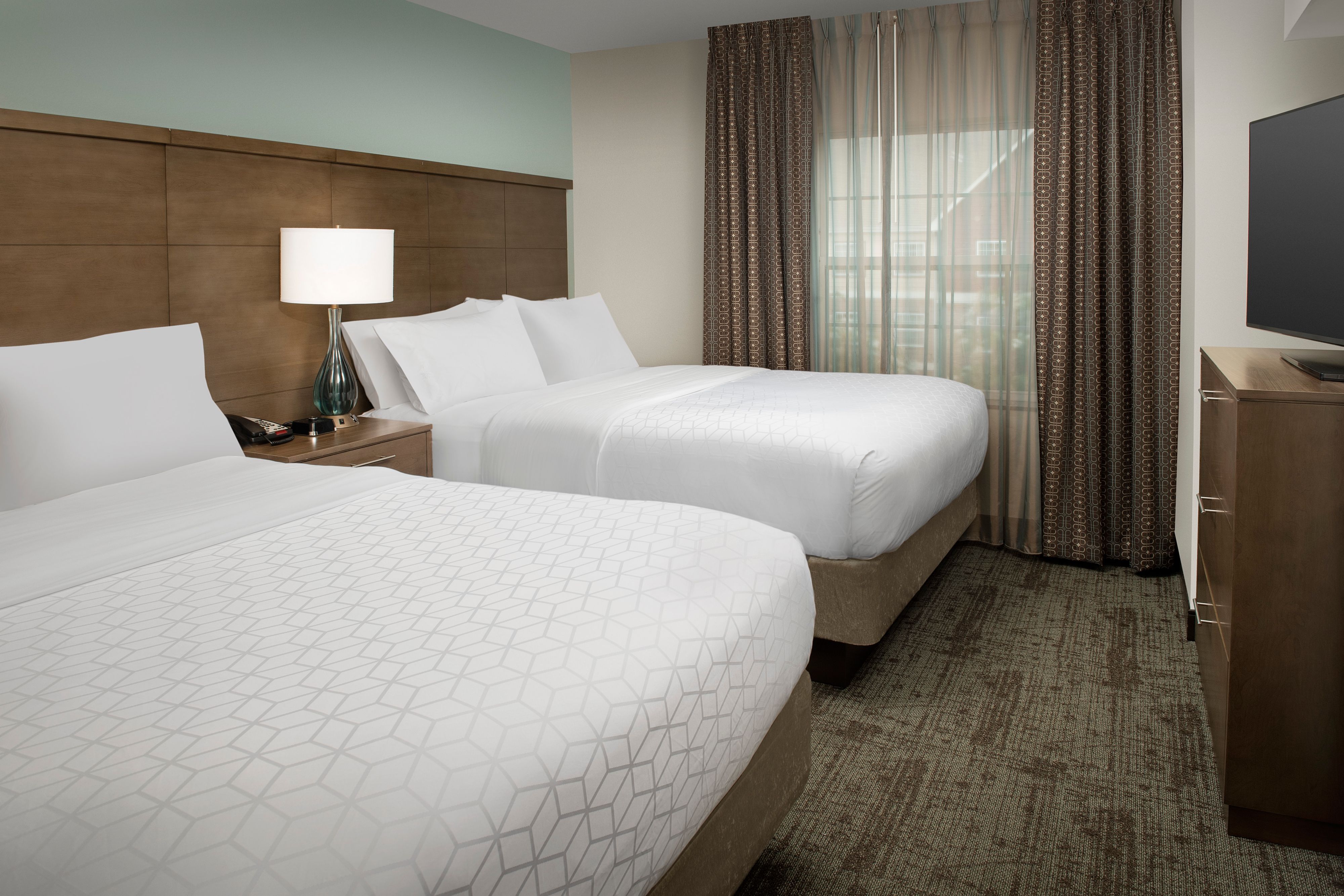 image Spacious bedroom featuring two comfortable beds with warm lighting.