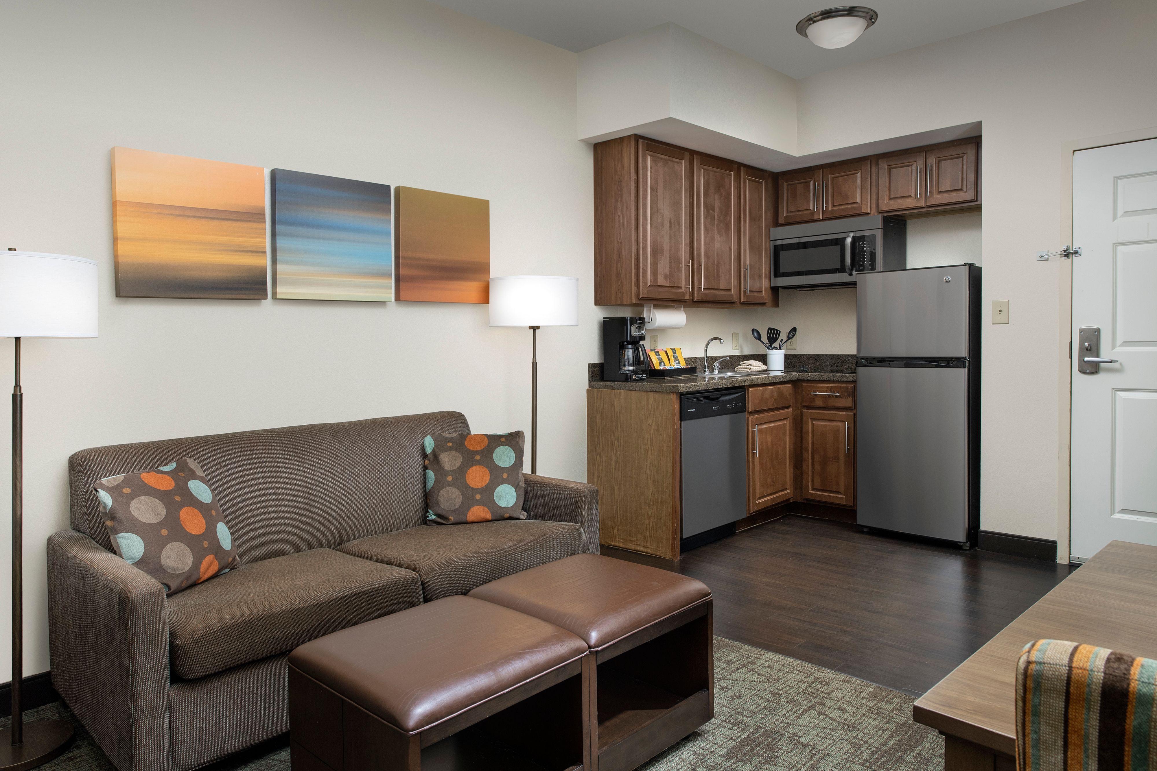 image Open living area with sofa, coffee table, and kitchen access.